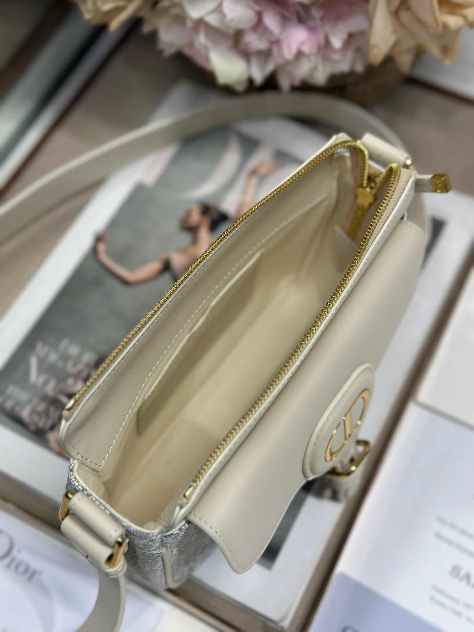 Dior 新款波比拉链小包 「椰子蓝D布配皮」
这款波比拉链手袋是二零二五春夏成衣系列新品，采用椰子蓝 Oblique 印花面料等材质精心制作，优雅实用的设计提升该系列的格调。浅饼干色调光滑牛皮革翻盖饰以复古金色饰面金属细节，饰以拉链开口，配可调节肩带，手提、肩背或斜挎。p560

翻盖开合
拉链开口
可调节、可拆卸的皮革带
内部插袋

型号：2358
尺寸：20 X13.5 X5.5 厘米（长 x 高 x 宽）