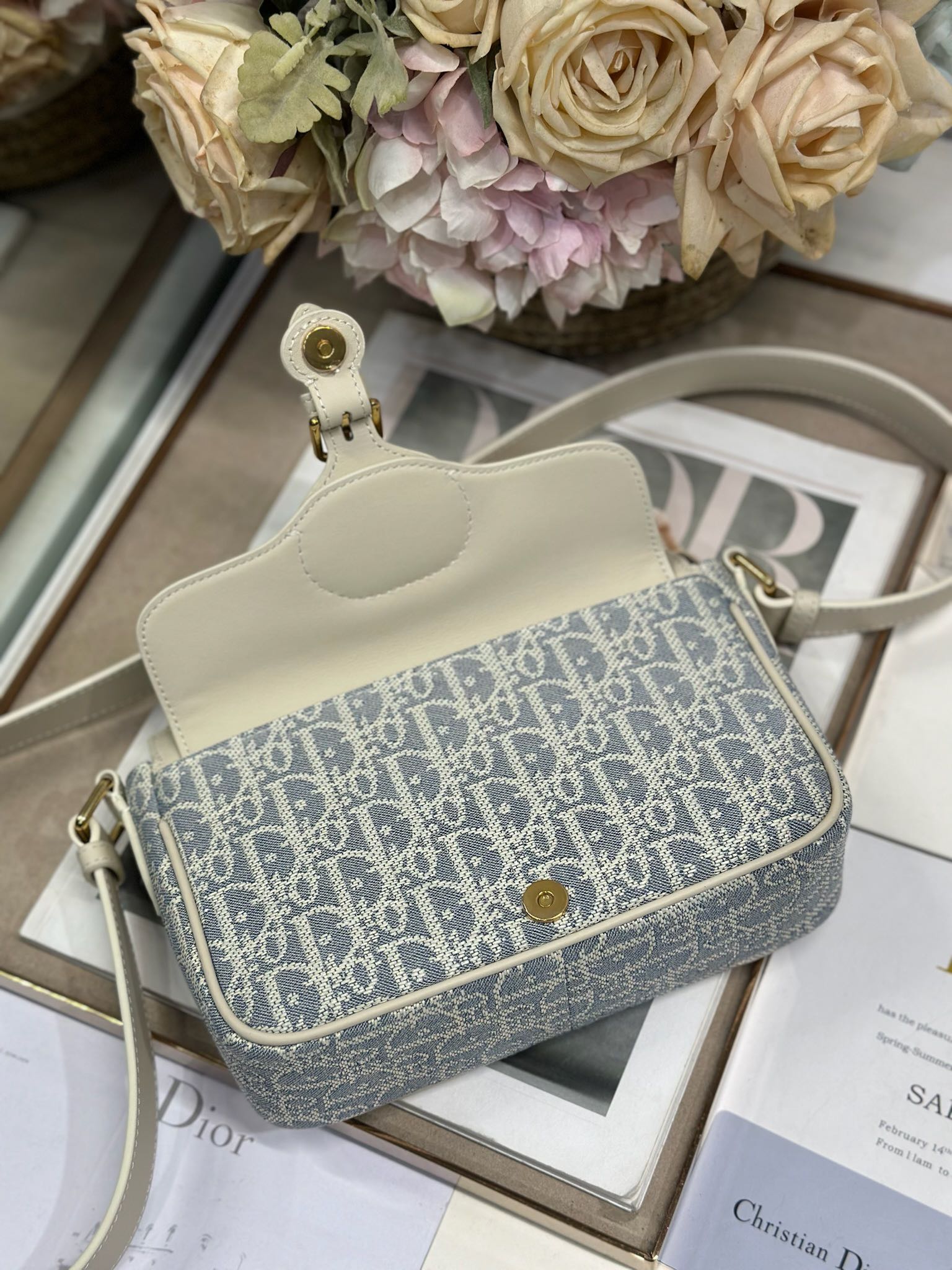 Dior 新款波比拉链小包 「椰子蓝D布配皮」
这款波比拉链手袋是二零二五春夏成衣系列新品，采用椰子蓝 Oblique 印花面料等材质精心制作，优雅实用的设计提升该系列的格调。浅饼干色调光滑牛皮革翻盖饰以复古金色饰面金属细节，饰以拉链开口，配可调节肩带，手提、肩背或斜挎。p560

翻盖开合
拉链开口
可调节、可拆卸的皮革带
内部插袋

型号：2358
尺寸：20 X13.5 X5.5 厘米（长 x 高 x 宽）