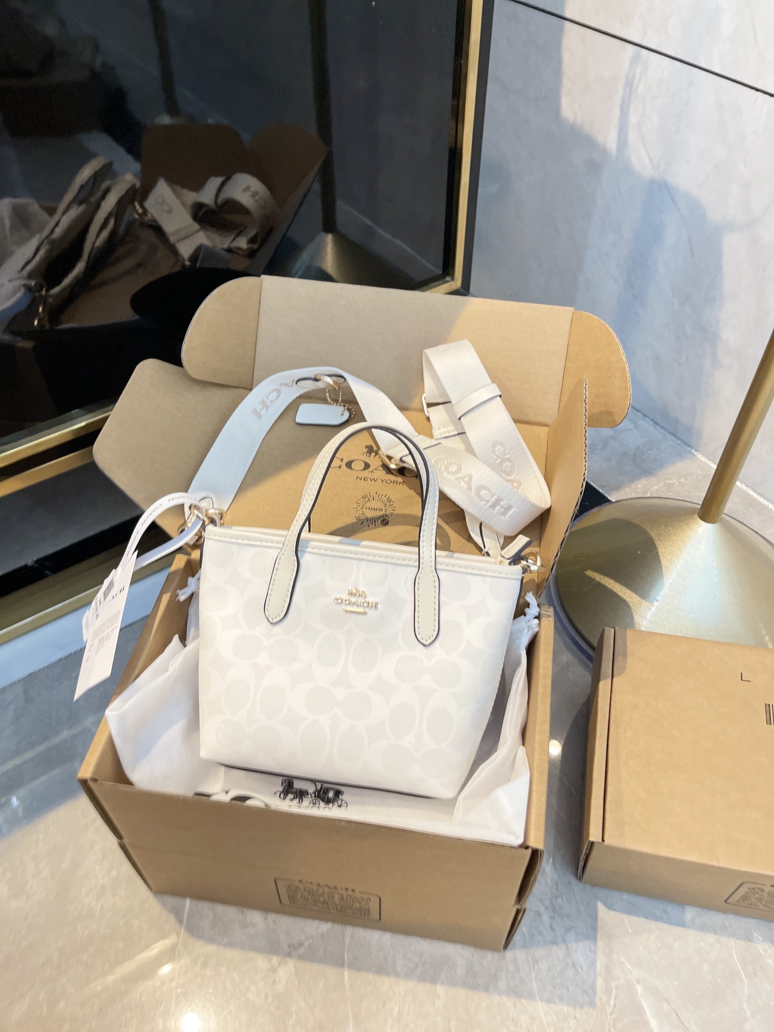 Mini tote de Coach en blanco glaciar, versión de compra por encargo. Este lote es ensamblado, el PVC viene di…