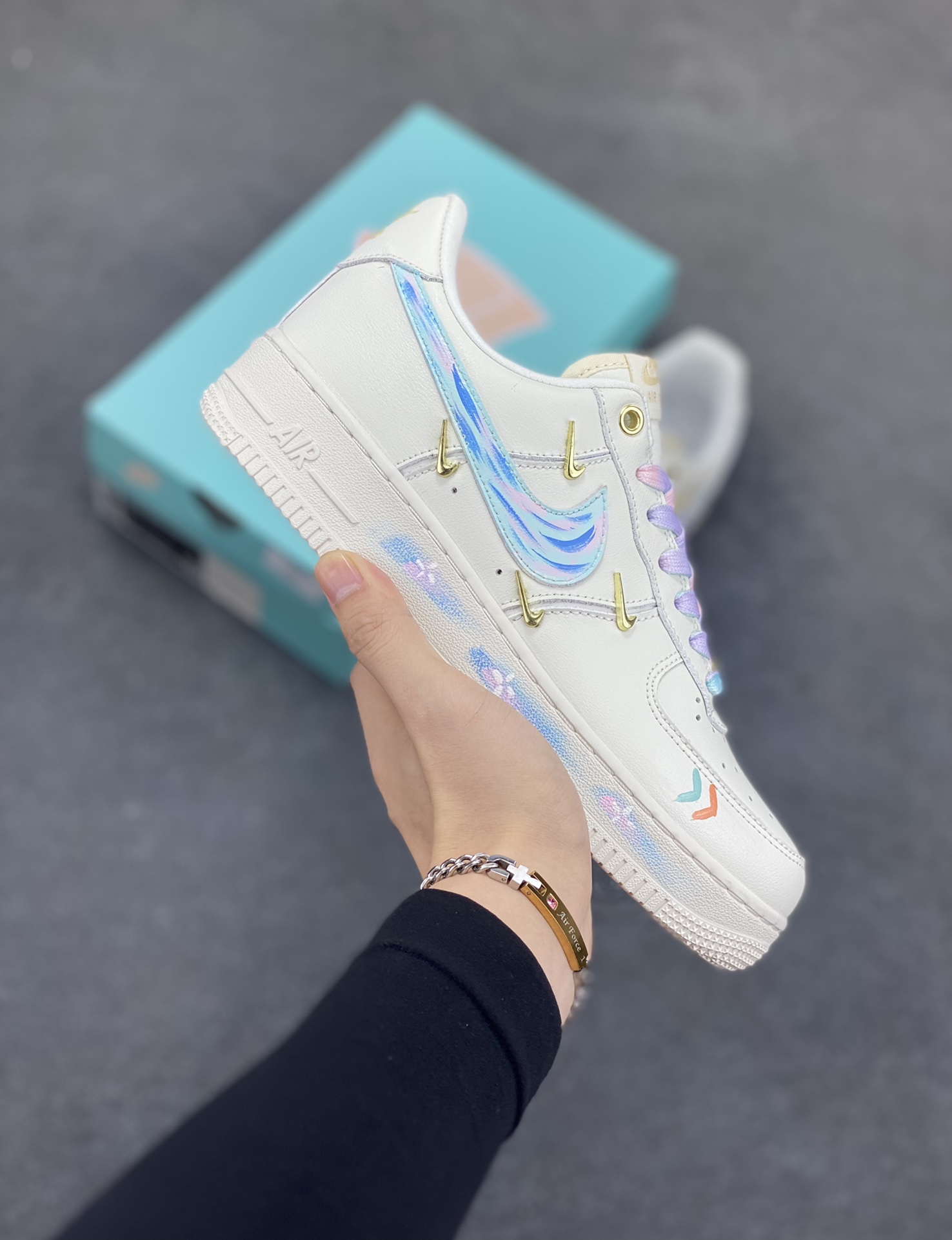 手绘涂鸦“莫奈印象”Nike Air Force 1 \'07 LX “Monet Impression”空军一号定制板鞋 这双鞋以纯净的白色作为底色，宛如一张等待艺术渲染的画布。莫奈印象派画作中那种光影交织、色彩斑斓的特点，被巧妙地运用到了鞋面设计中。鞋带部分采用了粉蓝等柔和的色彩，如同莫奈笔下天空与水波的交融，带来清新灵动之感 。鞋身侧面经典的 Nike Swoosh 标志，除了原本带有梦幻色彩的渐变图案，还缀以精致的金色小 Swoosh 标志，仿佛是莫奈画作中闪烁的光斑，为整体造型增添了一份奢华与精致 货号：FV3654-211 尺码：36 36.5 37.5 38 38.5 39 40 40.5 41 42 42.5 43 44 44.5 45-选品中心