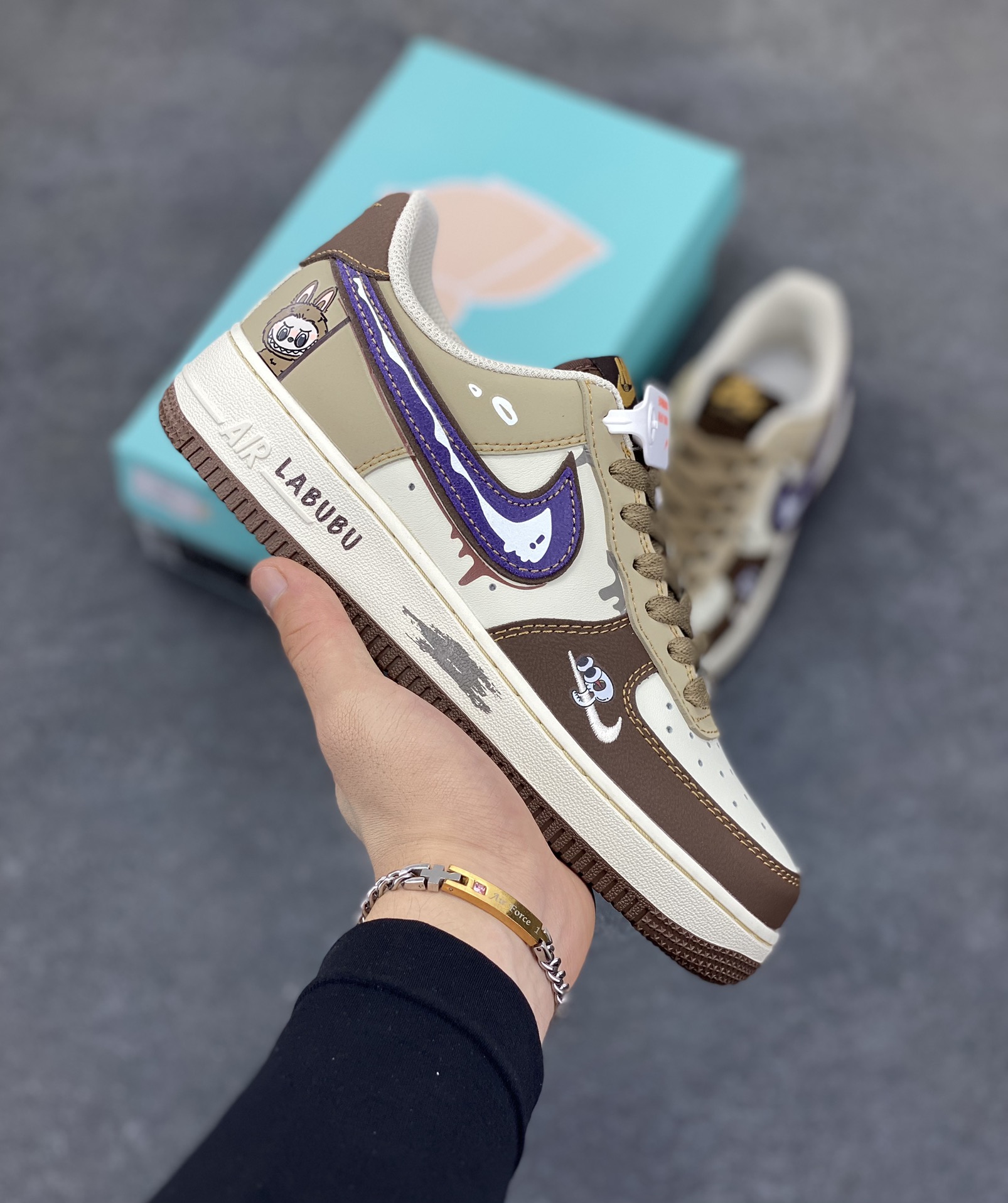 手绘涂鸦“潮趣labubu”空军一号定制板鞋 LABUBU 那萌趣又略带个性的形象，巧妙地绘制在鞋身之上，鞋身的配色经过精心设计，既有大地色系带来的沉稳质感，又有紫色钩子等细节处的亮眼点缀，就如同在低调与张扬之间找到了完美的平衡。而那些看似随意却又独具匠心的涂鸦笔触，更是为整双鞋增添了几分街头潮流的不羁与随性 货号：LJ8822-111 尺码：36 36.5 37.5 38 38.5 39 40 40.5 41 42 42.5 43 44 44.5 45-选品中心