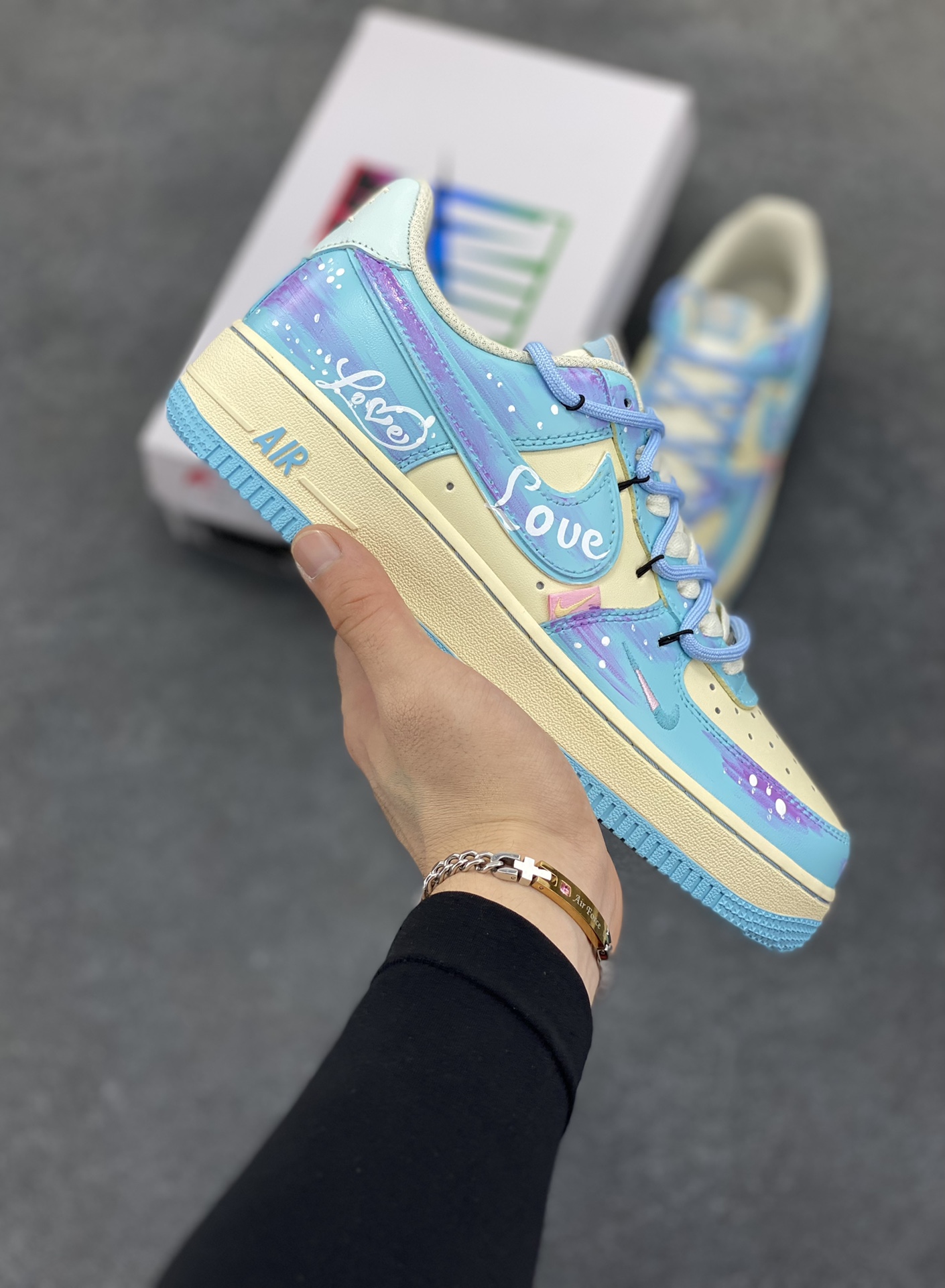 手绘涂鸦“海盐甜梦”“Sweet Dream of Sea Salt”空军一号定制板鞋 清透海盐蓝与柔雾紫交融，像将马卡龙色揉进云朵，鞋身 “Love” 元素化作无声情书，勾连起青春悸动。奶油中底与冰蓝外底，踩出云端漫步的轻盈，每一步都似在绵软甜梦里打转，把街头潮流与浪漫诗意，悄悄藏进日常步伐 货号：XL2332-555 尺码：36 36.5 37.5 38 38.5 39 40 40.5 41 42 42.5 43 44 44.5 45-选品中心
