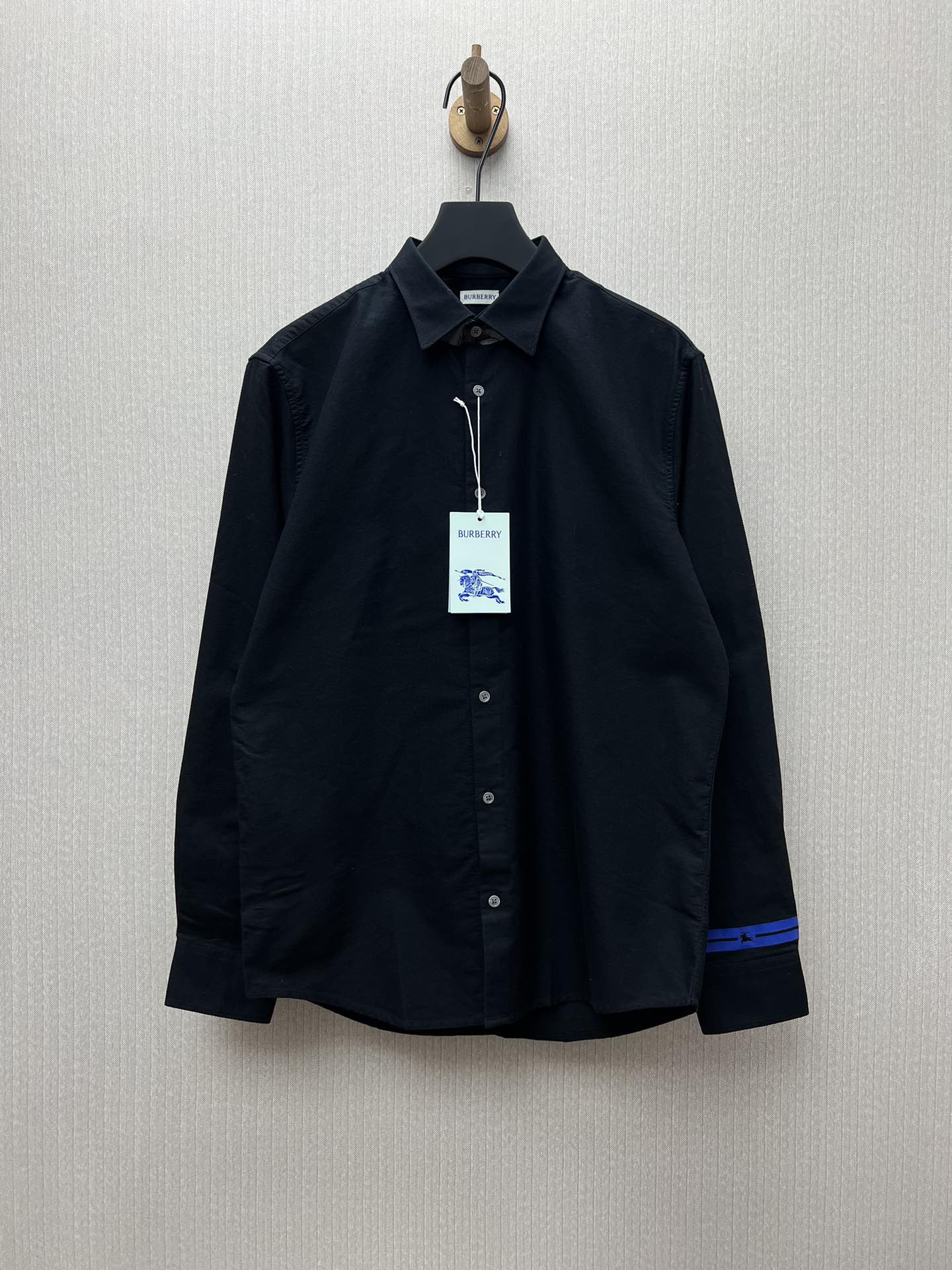 Nueva camisa Burberry 25ss de color liso de manga larga con rayas azules en los puños. Logotipo de la marca. Versión al…
