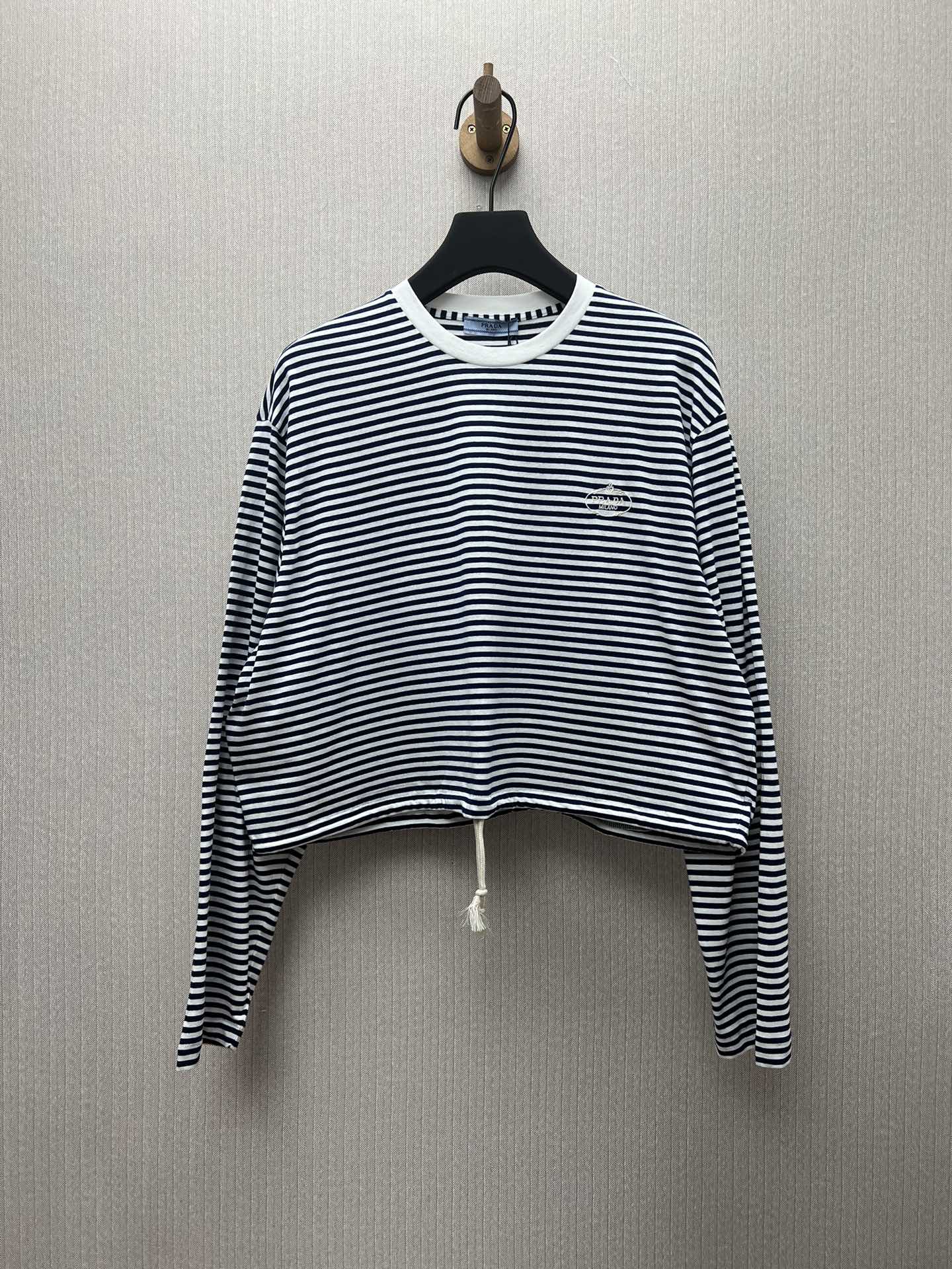 La nueva camiseta de manga larga Prada 25ss está confeccionada con tejido de punto a rayas, inspirada en el estilo náut…