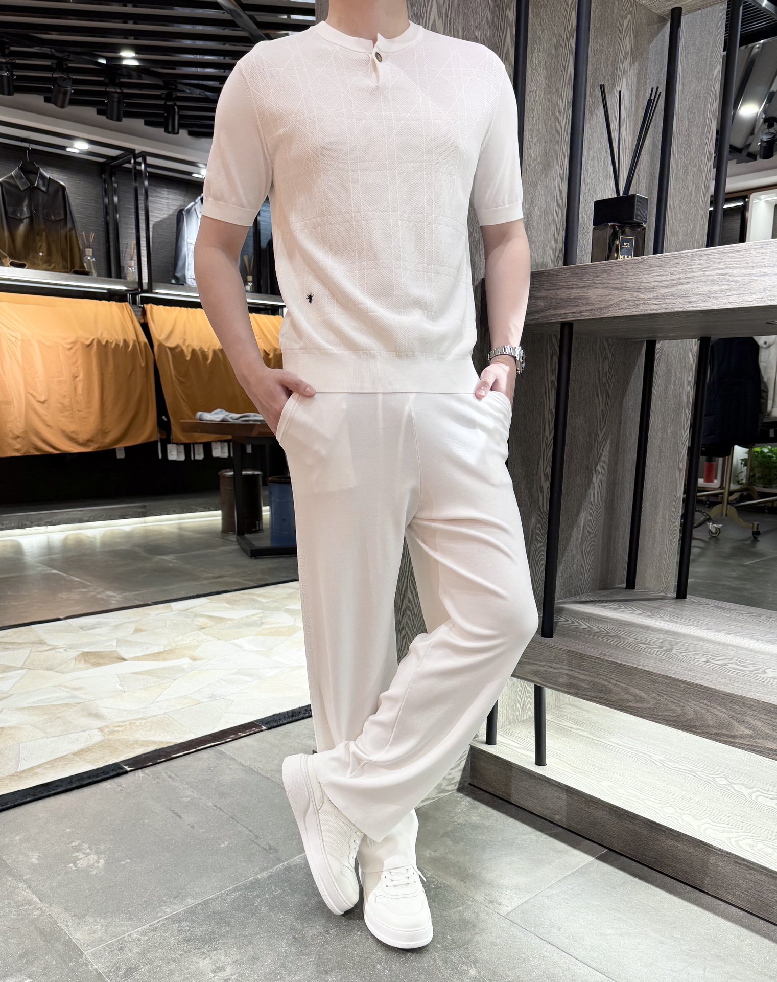 NO:506517,Dior - Little Bee Early Autumn Summer Style Old Qianfeng # Ice Honey Knitted Set Henry Collar Knitted Short Sleeve Logo Bee Embroidery Classic Plaid Texture on the Front 16G Density The thinner, the more delicate and flatter the fabric, has a good texture. Ice Honey is a knitted clothing fabric made of 80 rayon and 20 nylon wire intersected and twisted. It has the following characteristics: Touch and comfort. Cool and skin-friendly Ice Honey has good breathability and hydrophilicity. It can quickly absorb and dissipate sweat when worn, keep the skin dry and bring a cool feeling. The cloth surface feels delicate and comfortable, and it is comfortable to wear, which is not easy to cause skin allergies. Soft and smooth After being treated with soft finishing agent, the ice Honey fabric feels soft, smooth and elastic, and has no itchy feeling when worn, which can fit the body curve well and give people a comfortable wearing experience. Appearance characteristics  The color is bright and reactive printing and dyeing technology. The dyeing products are bright and natural. No matter what kind of light source, there is no flash or aurora phenomenon, and it is not easy to fade, and can maintain bright colors for a long time. The fabric with good drape has a certain weight and texture. After processing, it has a good drape. The lines of the clothing are smooth, elegant and free, and can show an elegant temperament. Performance advantages: High hygroscopic viscose fiber content, which makes ice-seed fabrics highly absorbent, absorb moisture in the air and emit it, adjust the humidity on the skin surface, and maintain a comfortable wearing environment. Good wrinkle resistance is treated with excellent wrinkle smoothing agent. The ice-seed fabric does not crease when it is dried after washing, has good wrinkle resistance, and can maintain the flat appearance of the clothes and reduce the trouble of ironing.  The addition of sturdy and durable nylon silk gives ice-seed fabric a certain degree of fastness and wear resistance, making it not easy to break during daily wear and washing, and it is not easy to wrinkle after pulling or rubbing, and has good dimensional stability. Size 48-56 (model 180/140 wear 50, equipped with Hong Kong Lane Crawford packaging), dior, T-shirt, alexander wang19860909迪奥-小蜜蜂早秋夏款 老钱风#冰麻针织套装 亨利领针织短袖 标识小蜜蜂刺绣 正面经典格织纹 16G的密度 面料薄、越细腻平整,具有较好的质感 冰麻是一种针织服饰用面料,由80人造丝和20锦纶丝交并加捻制成,具有以下特色 触感与舒适度 凉爽亲肤冰麻具有良好的透气性和亲水性,穿着时能快速吸收和散发汗液,使皮肤保持干爽,带来凉爽的感觉,且布面触感细腻,贴身穿着舒适,不易引发皮肤过敏. 柔软顺滑经过柔软整理剂处理后,冰麻面料手感柔软、滑爽,富有弹性,穿着时无刺痒感,能很好地贴合身体曲线,给人舒适的穿着体验. 外观特性 色泽鲜艳采用活性印染技术,染色物色泽鲜艳、自然,无论在何种光源下,都无闪光、极光现象,且不易褪色,能长久保持亮丽的色彩. 悬垂性好面料具有一定的重量和质感,加工后具有良好的悬垂感,制成的服装线条流畅,飘逸洒脱,能展现出优雅的气质. 性能优势 吸湿性强粘胶纤维含量高,使得冰麻面料吸湿性强,能吸收空气中的水分并散发出去,调节皮肤表面的湿度,保持舒适的穿着环境. 抗皱性好经优良的抗皱平滑剂处理,冰麻面料在洗涤后干燥时不产生折痕,具有较好的抗皱性能,能保持衣物的平整外观,减少熨烫的麻烦. 坚固耐用锦纶丝的加入赋予了冰麻面料一定的坚牢度和耐磨性,使其在日常穿着和洗涤过程中不易破损,拉扯或摩擦后也不易起皱,具有较好的尺寸稳定性. 尺码48-56（模特180/140穿50,配香港连卡佛包装）,,dior,T-shirt,alexander wang,Men's clothing