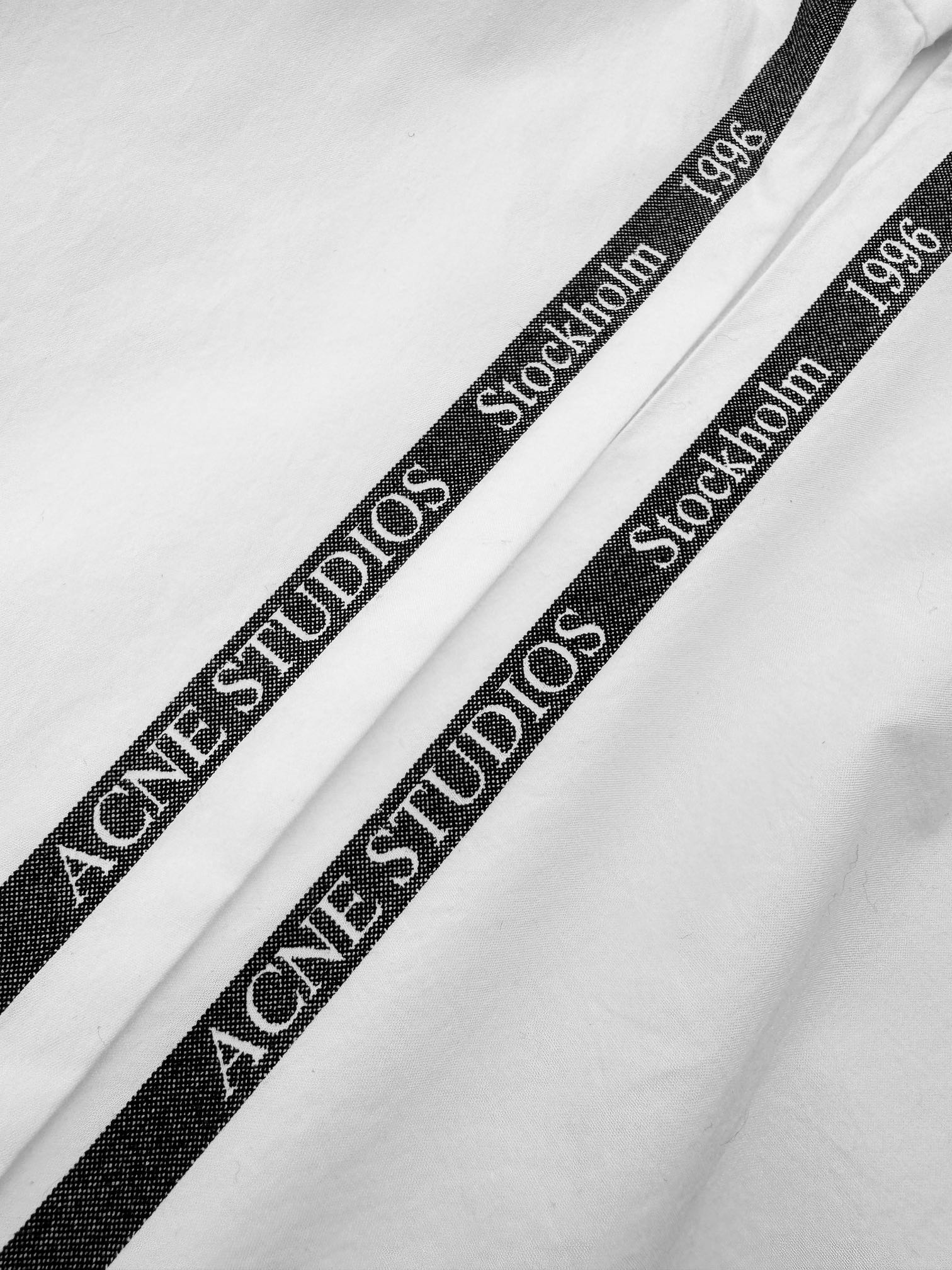 。Acne Studios 提花徽标衬衫定制瑬光天丝云柔缎 轻盈垂顺 舒适贴肤 以纯粹与洁净的白色做主色