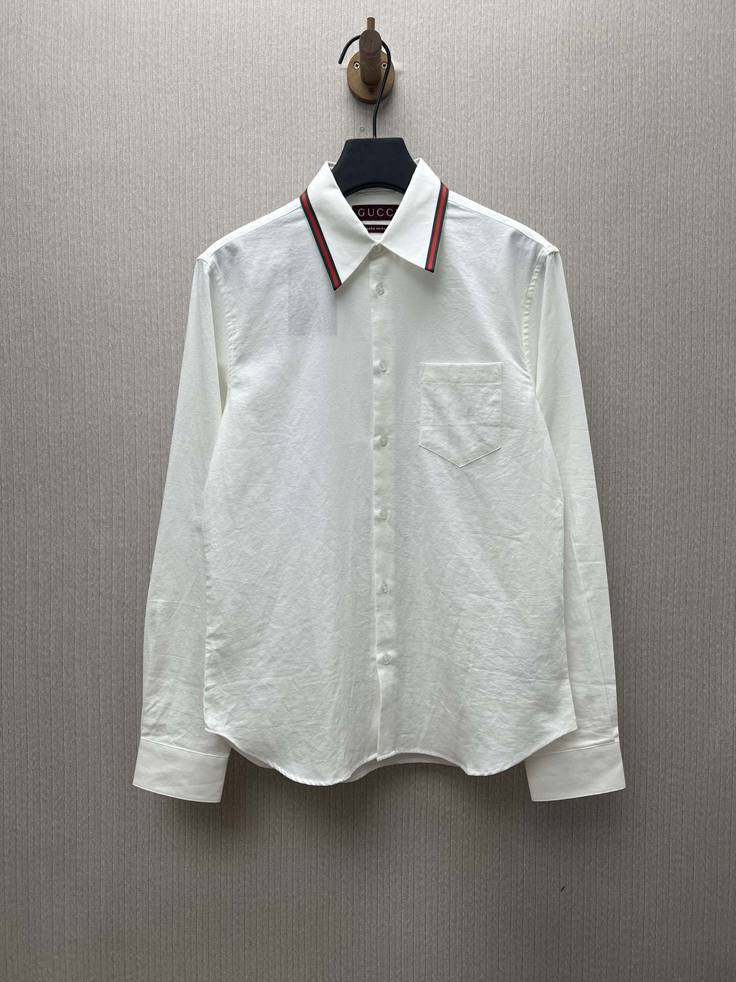 G 25ss Nueva camisa de algodón oxford con cinta de rayas en todo el cuello, y botones de nácar que resaltan el encanto.…