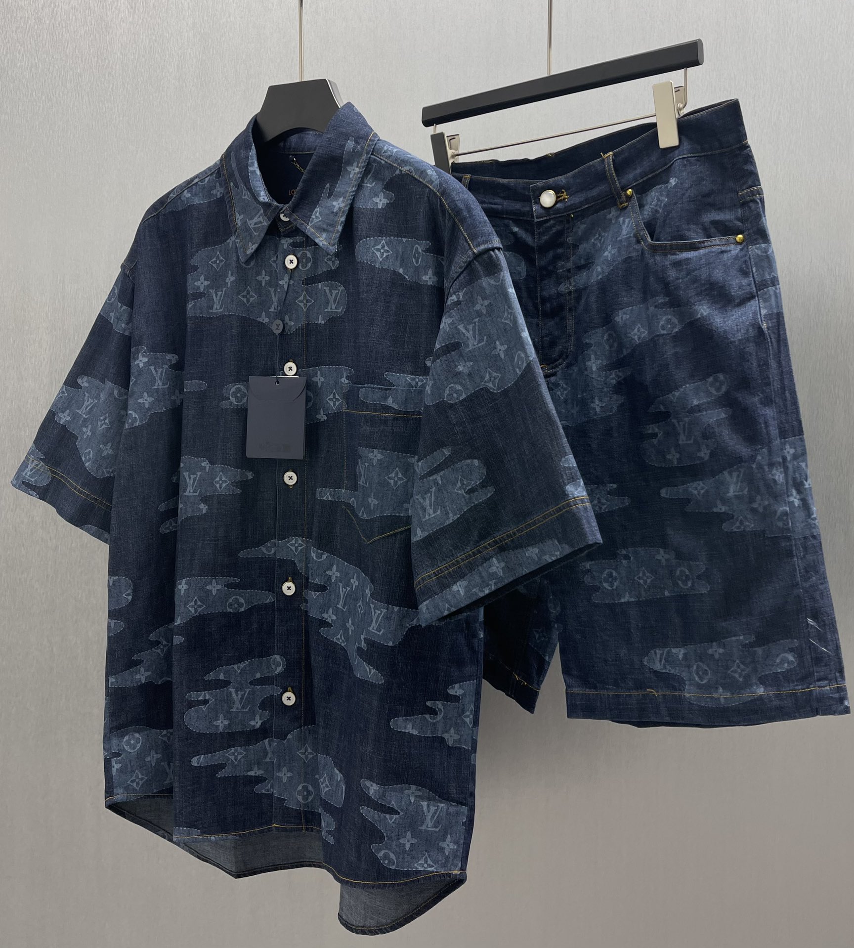 P210🧧LU云朵青年布短衬衫
Size : S-XL
本款青年布短袖衬衫令宛若云朵的 Monogram 贴饰漂浮于深邃背景，，与 2025 秋冬秀场的Monogram Clouds 印花异曲同工。正绒面革 Marque LVuitton Deposee 标签栖身后部，醒目明线和珠光纽扣丰富细节。可与同款短裤共筑考究造型，成就夏日清新之选。