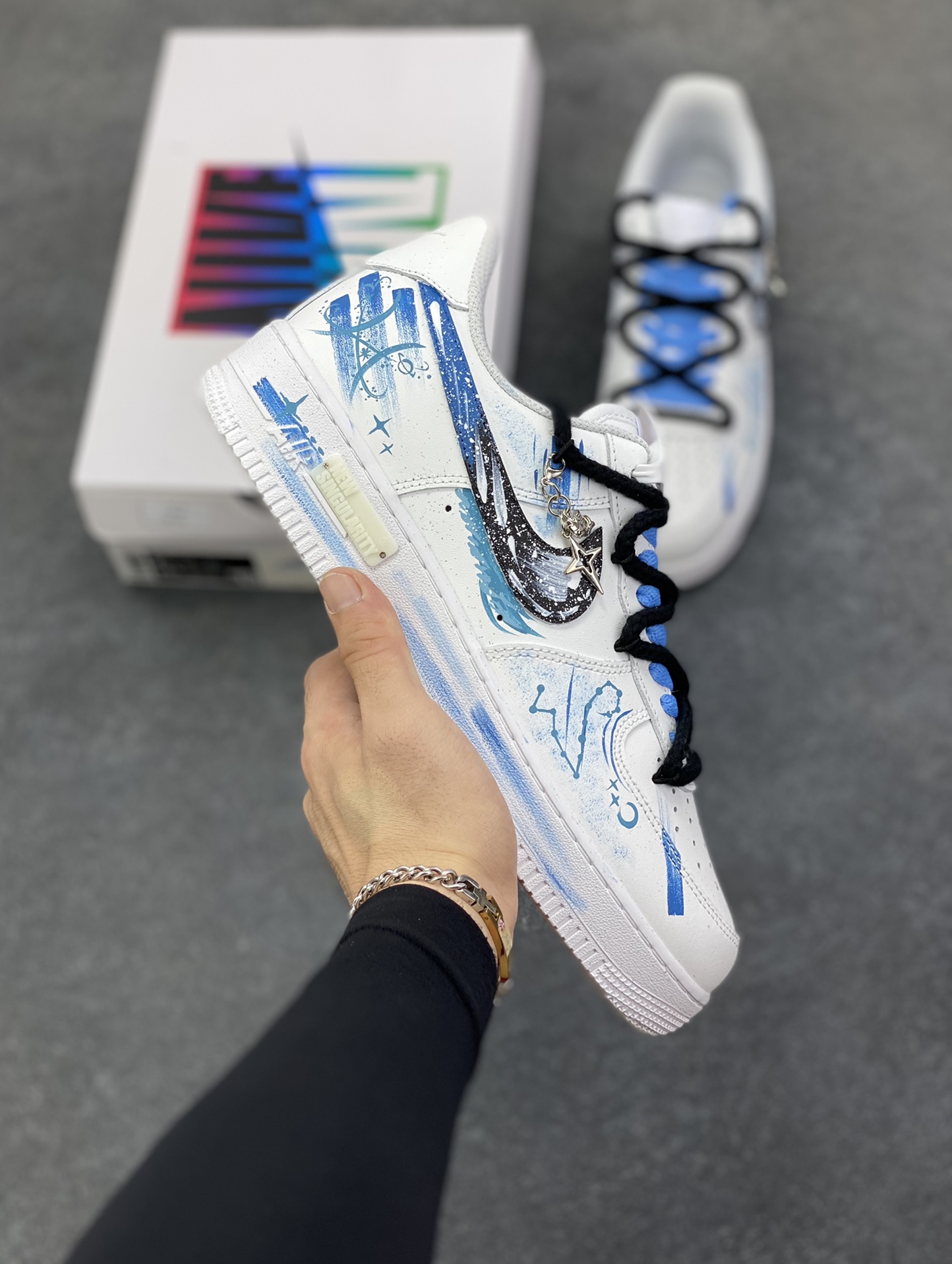 手绘涂鸦“双鱼座”十二星座系列 Nike Air Force 1 “Pisces”空军一号定制板鞋 以梦幻蓝白为主色调，将双鱼座元素融入手绘涂鸦，鞋身似洒满星辰的海面，灵动飘逸。经典 Swoosh 与星座符号巧妙结合，搭配精致挂饰，细节处尽显浪漫巧思。作为定制款，它不仅是潮流穿搭利器，更如为双鱼打造的专属星海，承载着对星座文化的独特诠释，让每一步都似在星海中漫游，休闲又充满梦幻氛围 货号：星座219-320 尺码：36 36.5 37.5 38 38.5 39 40 40.5 41 42 42.5 43 44 44.5 45\