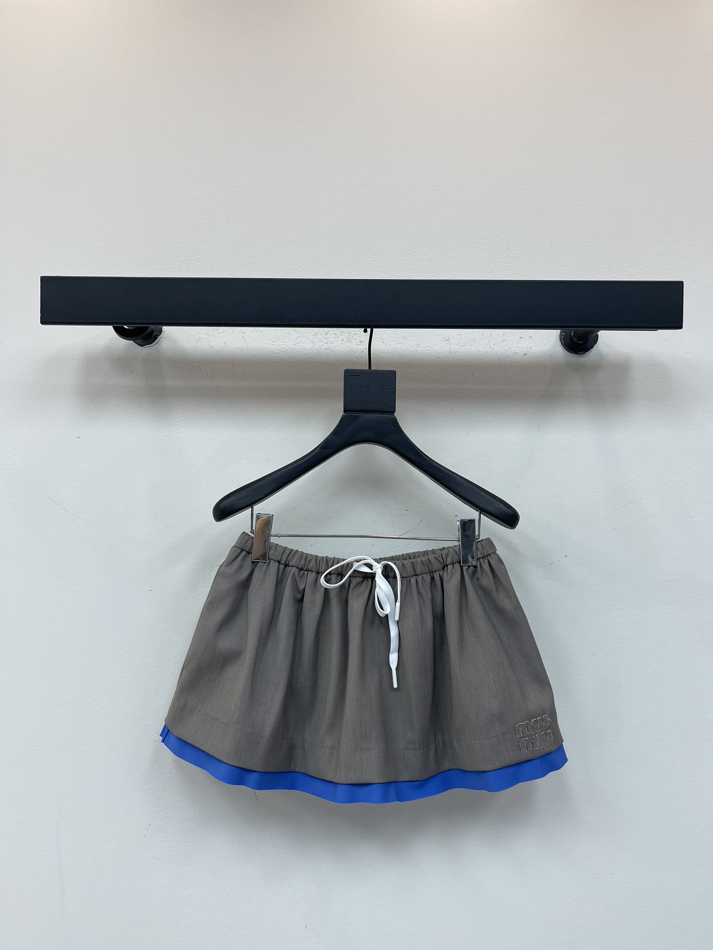 NO:490540,Miumi*25 early autumn new Gada mini splicing skirt. As Miu's signature fabric, Gada's re-interpretation of the silhouette of this mini skirt is matched with periwinkle poplin details and sporty drawstrings to add a modern experimental style. Exquisite craftsmanship and innovative experiments are combined with elastic waist and drawstring decoration. Blue splicing embellishments at the end of the skirt add a sense of design to the entire skirt, A-shaped style, side letter logo design. SML, miumiu, skirts, alexander wang19860909Miumi*25早秋新款华达呢迷你拼接半身裙.华达呢作为Miu标志性面料,重释这款迷你半身裙的廓形,搭配长春花府绸细节和运动风抽绳,增添现代实验风格.精湛工艺与创新实验相结合,松紧腰搭配抽绳装饰,裙尾蓝色拼接点缀给整条裙子增添了设计感,A字版型,侧边字母徽标设计.SML,,miumiu,skirts,alexander wang,Women's clothing