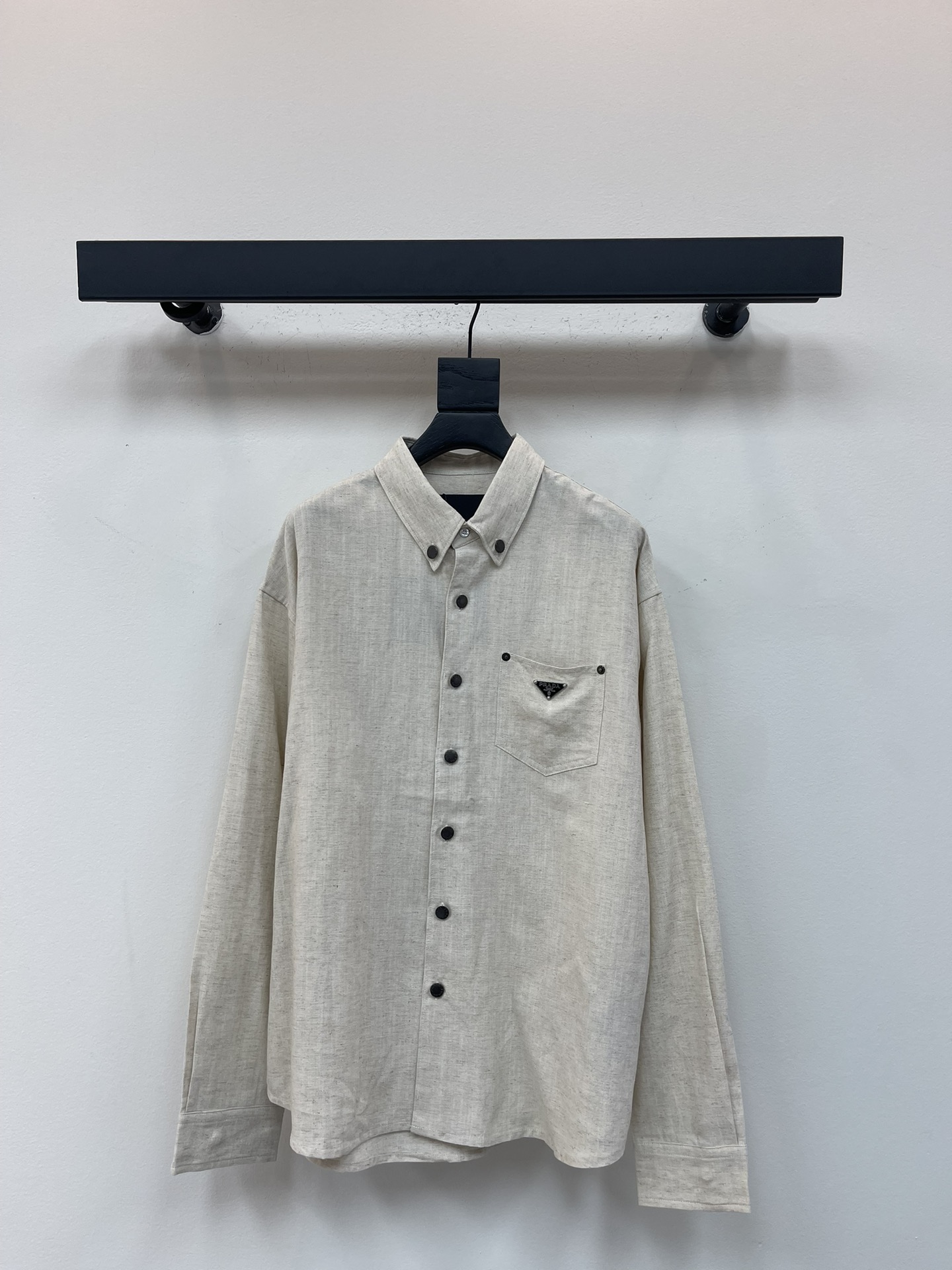 NO:494335,Prad*25 new inverted triangle iron mark pocket Tencel linen cotton long-sleeved shirt. Tencel linen cotton fabric is fixedly weaved and dyed, with lump patterns on the surface. The buttons are made of copper as old bronze black, laser engraved on the surface, and the same color as the bottom is worn low. The white buttons on the neck are made of tree material. The soft and delicate texture makes this shirt the best choice for summer crisp clothing. The square silhouette expresses contemporary charm, while the metal triangle logo highlights the brand's classic style. The same style for men and women!  Size chart S-XL, prada,shirts,alexander wang19860909Prad*25新款倒三角铁标口袋天丝麻棉长袖衬衫.天丝麻棉面料,定织定染,面上带有麻点纹路.纽扣采用铜料做旧古铜黑色,面上激光刻字,底部搭配同色做旧低.领口白色纽扣采用树材料.柔软细腻的质地让这款衬衫成为了夏日挺括衣装的不二之选.方正廓形表达当代魅力,而金属三角形徽标彰显品牌经典格调.男女同款！ 尺码表S-XL,,prada,shirts,alexander wang,Women's clothing