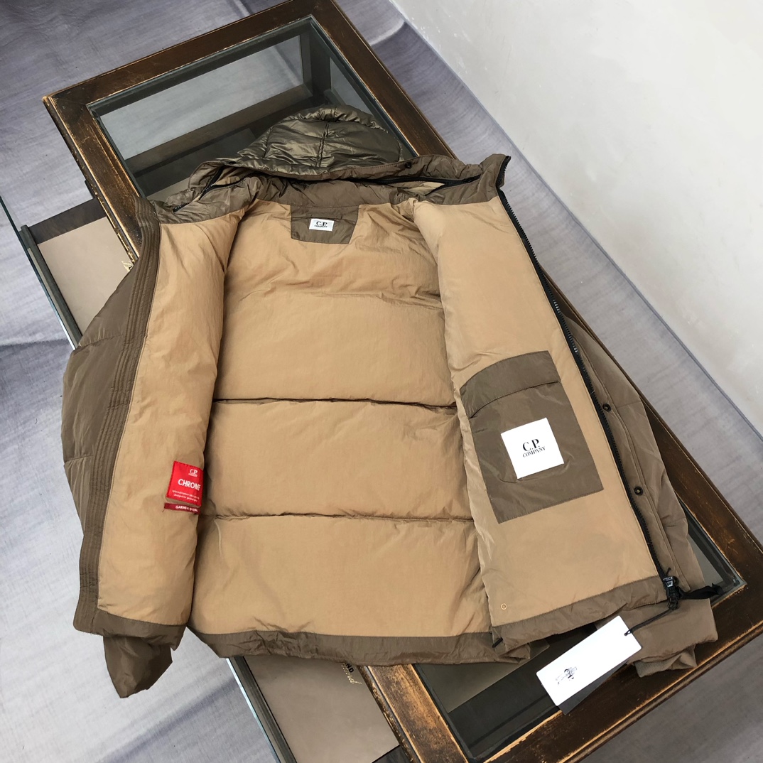 p625.00 CP.COMPANY新款专柜同步，CP经典防风镜片羽绒服，90进口羽绒 特殊高密记忆面料原厂染色防水配色，防风保暖袖口具备上身体感保温舒适度极好  简洁大方的设计 深受户外旅游爱好人士偏爱 也适合平时商务穿着的百搭款 所有辅料原版定制 实物拍照 现货供应！！  
颜色：黑色  卡其色  灰色
尺码：M-L-XL-2XL
​