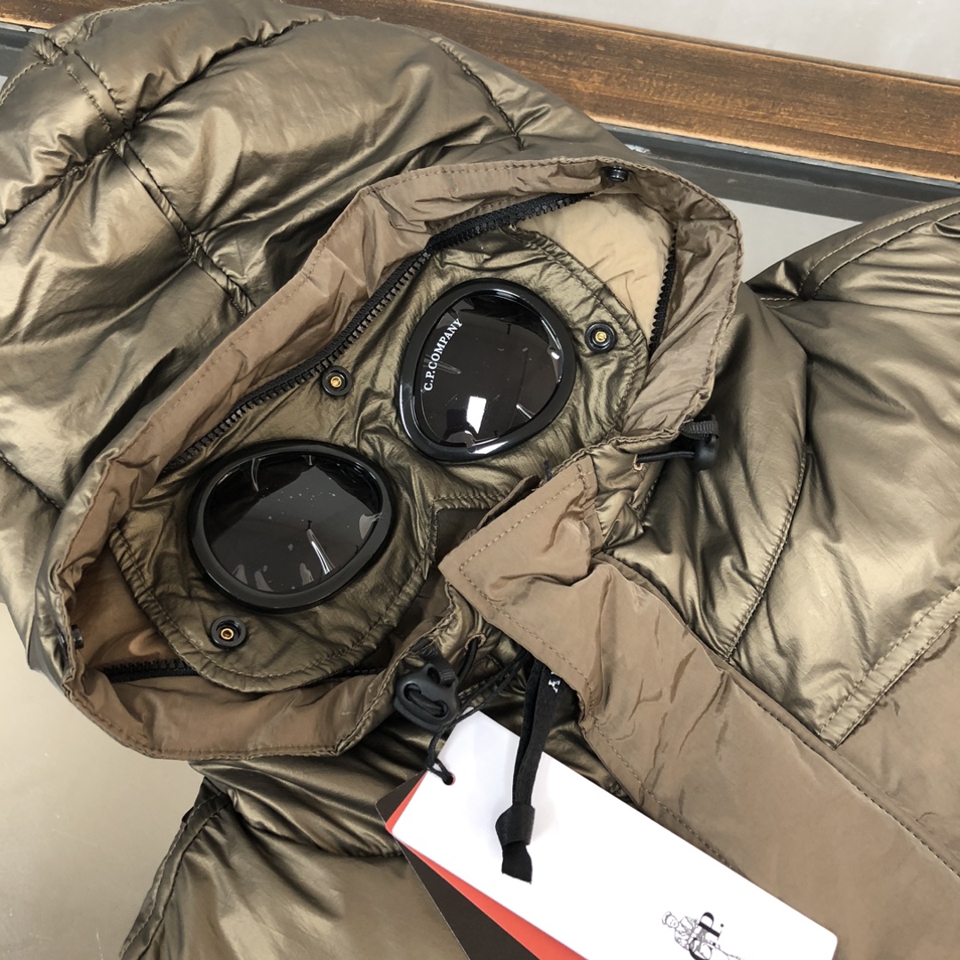 p625.00 CP.COMPANY新款专柜同步，CP经典防风镜片羽绒服，90进口羽绒 特殊高密记忆面料原厂染色防水配色，防风保暖袖口具备上身体感保温舒适度极好  简洁大方的设计 深受户外旅游爱好人士偏爱 也适合平时商务穿着的百搭款 所有辅料原版定制 实物拍照 现货供应！！  
颜色：黑色  卡其色  灰色
尺码：M-L-XL-2XL
​