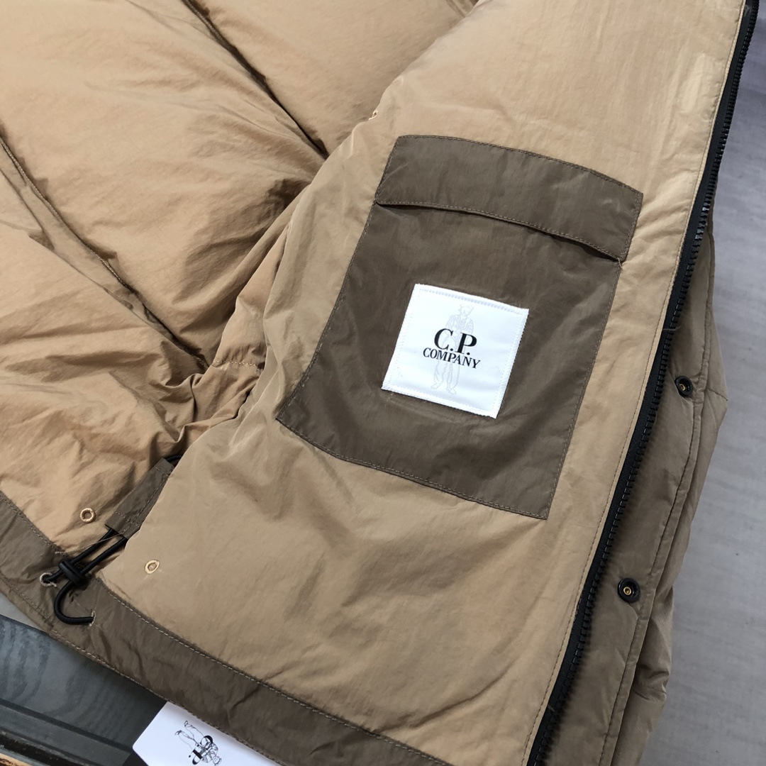p625.00 CP.COMPANY新款专柜同步，CP经典防风镜片羽绒服，90进口羽绒 特殊高密记忆面料原厂染色防水配色，防风保暖袖口具备上身体感保温舒适度极好  简洁大方的设计 深受户外旅游爱好人士偏爱 也适合平时商务穿着的百搭款 所有辅料原版定制 实物拍照 现货供应！！  
颜色：黑色  卡其色  灰色
尺码：M-L-XL-2XL
​