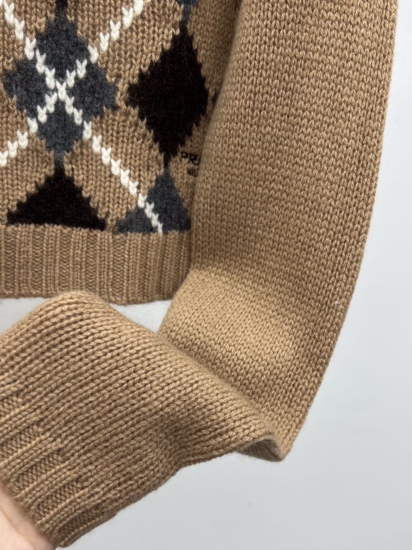 Prad*羊绒菱格毛衣此款修身版型毛衣采用羊绒面料织就配有半插肩袖子 结合简约与精致搭配裤子裙装都可 复