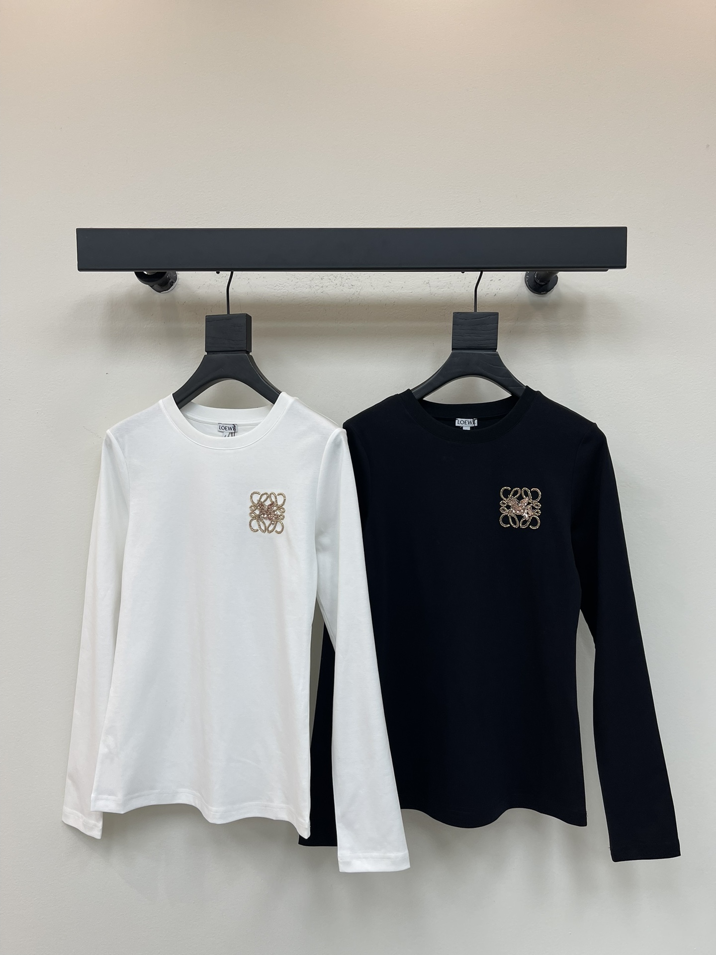 NO:495723,Loew*25 early autumn new round neck beaded long-sleeved top custom YB native cotton material breathable and comfortable, full texture. Regular round neck top cut to highlight the brand style. Made of gram-weight pure cotton, elastic and close-fitting, presenting a slim visual effect. The whole garment chest uses bead embroidery to outline the three-dimensional style totem logo to enhance brand identity. Fashionable and high-end feel immediately create a personal style. Fashionable and relaxed. The inner wear is brilliant and fashionable. SML,,loewe,alexander wang19860909Loew*25早秋新款圆领钉珠长袖上衣 定制YB原生全棉材质 透气舒适 质感十足 常规圆领上衣裁剪 凸显品牌格调 采用克重纯棉制成 弹性贴身感十足 呈现显瘦视觉效果 整件成衣胸前利用钉珠刺绣工艺勾勒出立体风格的图腾徽标 加强品牌标识度 时尚高级感立现 打造个性风格 时髦松弛 单穿内搭都出彩时髦 SML,,loewe,alexander wang,Women's clothing