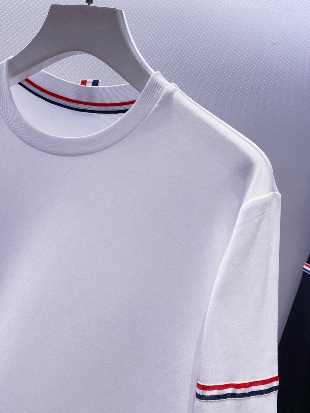 TB~袖臂经典织带嵌花薄太空棉长袖T恤衫
秋冬新款
ThomB&hellip;太空薄棉长袖T恤、解锁先锋穿搭密码.. 将经典与创新融合，用细节诠释品质，邀你共赴这场时尚之约，解锁独属于你的潮流穿搭。
袖臂处经典织带标识嵌花，红白蓝三色交织，是Thom Br..标志性元素，以精湛工艺融入衣物，如同品牌名片，举手投足间彰显独特品味，是低调中的高调宣言 ，无论是日常出街还是社交场合，都能让你成为目光焦点。
匠心剪裁，设计感拉满。前短后长的衣摆设计，打破常规，塑造出独特的层次感，行走间衣角轻扬，尽显灵动与随性；下摆两侧开叉处同样点缀织带，为整体造型增添细节亮点，更在不经意间流露精致态度，轻松提升穿搭的时髦指数 。
选用太空薄棉面料，奢护每寸肌肤，轻盈似云朵，贴肤感满分，透气性绝佳，能保持清爽。细密的纺织工艺，让面料柔软又有韧性，耐穿且不易变形，为你带来持久的舒适体验。是休闲潮流时尚的首选之一。

颜色：白色、黑色
规格：S--XXL
    P210
M码:肩宽45.胸围106. 前衣长66. 后衣长71.袖长62
L码：肩宽46.胸围110.前衣长67.后衣长72.袖长63