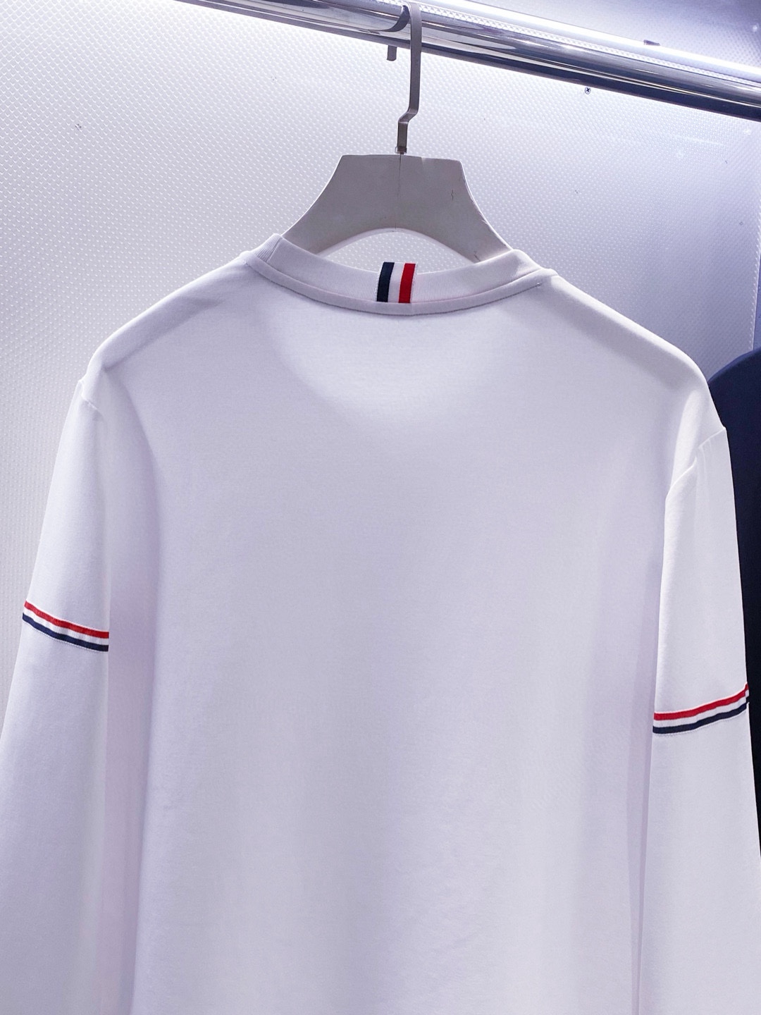 TB~袖臂经典织带嵌花薄太空棉长袖T恤衫
秋冬新款
ThomB&hellip;太空薄棉长袖T恤、解锁先锋穿搭密码.. 将经典与创新融合，用细节诠释品质，邀你共赴这场时尚之约，解锁独属于你的潮流穿搭。
袖臂处经典织带标识嵌花，红白蓝三色交织，是Thom Br..标志性元素，以精湛工艺融入衣物，如同品牌名片，举手投足间彰显独特品味，是低调中的高调宣言 ，无论是日常出街还是社交场合，都能让你成为目光焦点。
匠心剪裁，设计感拉满。前短后长的衣摆设计，打破常规，塑造出独特的层次感，行走间衣角轻扬，尽显灵动与随性；下摆两侧开叉处同样点缀织带，为整体造型增添细节亮点，更在不经意间流露精致态度，轻松提升穿搭的时髦指数 。
选用太空薄棉面料，奢护每寸肌肤，轻盈似云朵，贴肤感满分，透气性绝佳，能保持清爽。细密的纺织工艺，让面料柔软又有韧性，耐穿且不易变形，为你带来持久的舒适体验。是休闲潮流时尚的首选之一。

颜色：白色、黑色
规格：S--XXL
    P210
M码:肩宽45.胸围106. 前衣长66. 后衣长71.袖长62
L码：肩宽46.胸围110.前衣长67.后衣长72.袖长63