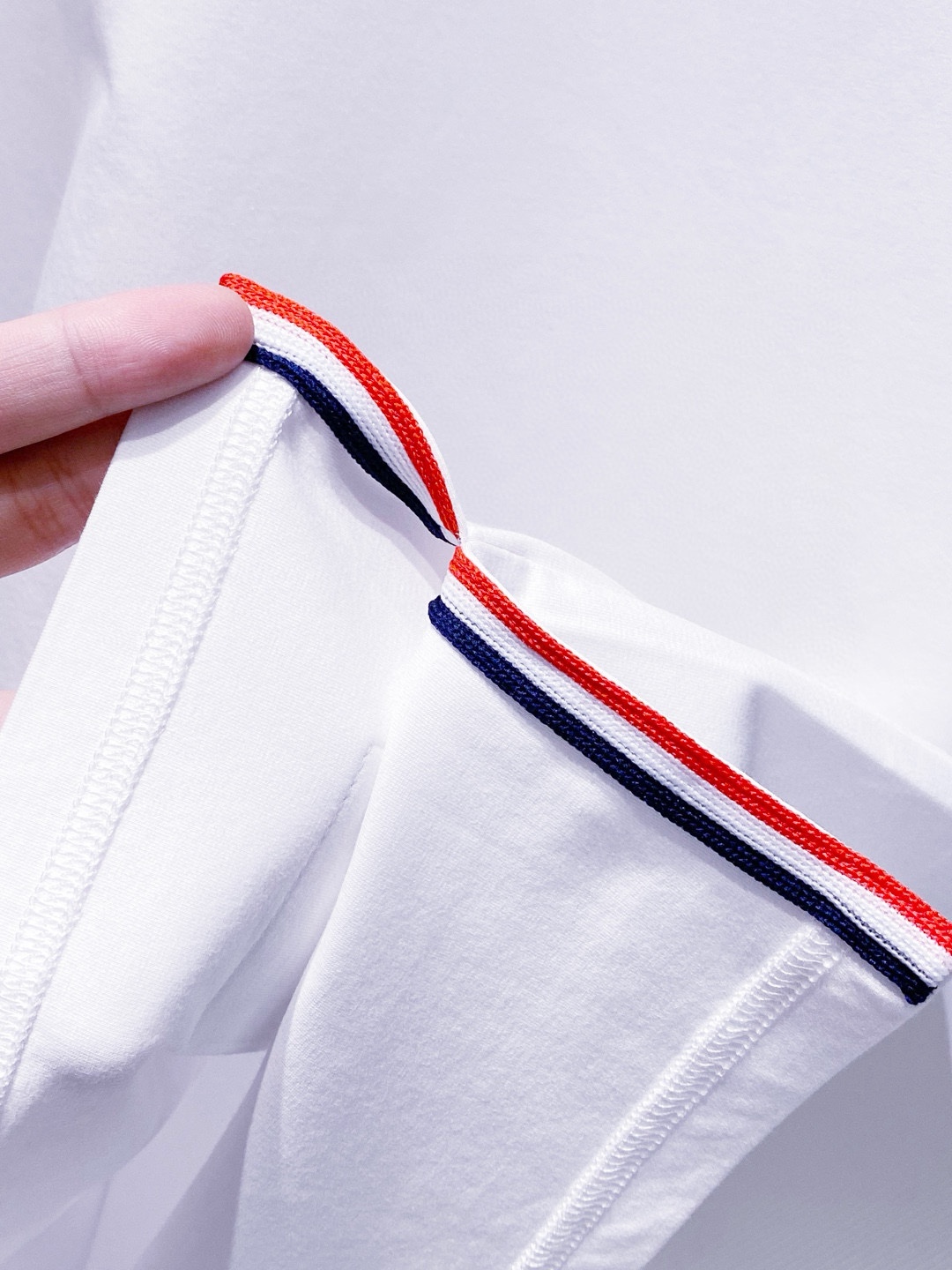 TB~袖臂经典织带嵌花薄太空棉长袖T恤衫
秋冬新款
ThomB&hellip;太空薄棉长袖T恤、解锁先锋穿搭密码.. 将经典与创新融合，用细节诠释品质，邀你共赴这场时尚之约，解锁独属于你的潮流穿搭。
袖臂处经典织带标识嵌花，红白蓝三色交织，是Thom Br..标志性元素，以精湛工艺融入衣物，如同品牌名片，举手投足间彰显独特品味，是低调中的高调宣言 ，无论是日常出街还是社交场合，都能让你成为目光焦点。
匠心剪裁，设计感拉满。前短后长的衣摆设计，打破常规，塑造出独特的层次感，行走间衣角轻扬，尽显灵动与随性；下摆两侧开叉处同样点缀织带，为整体造型增添细节亮点，更在不经意间流露精致态度，轻松提升穿搭的时髦指数 。
选用太空薄棉面料，奢护每寸肌肤，轻盈似云朵，贴肤感满分，透气性绝佳，能保持清爽。细密的纺织工艺，让面料柔软又有韧性，耐穿且不易变形，为你带来持久的舒适体验。是休闲潮流时尚的首选之一。

颜色：白色、黑色
规格：S--XXL
    P210
M码:肩宽45.胸围106. 前衣长66. 后衣长71.袖长62
L码：肩宽46.胸围110.前衣长67.后衣长72.袖长63