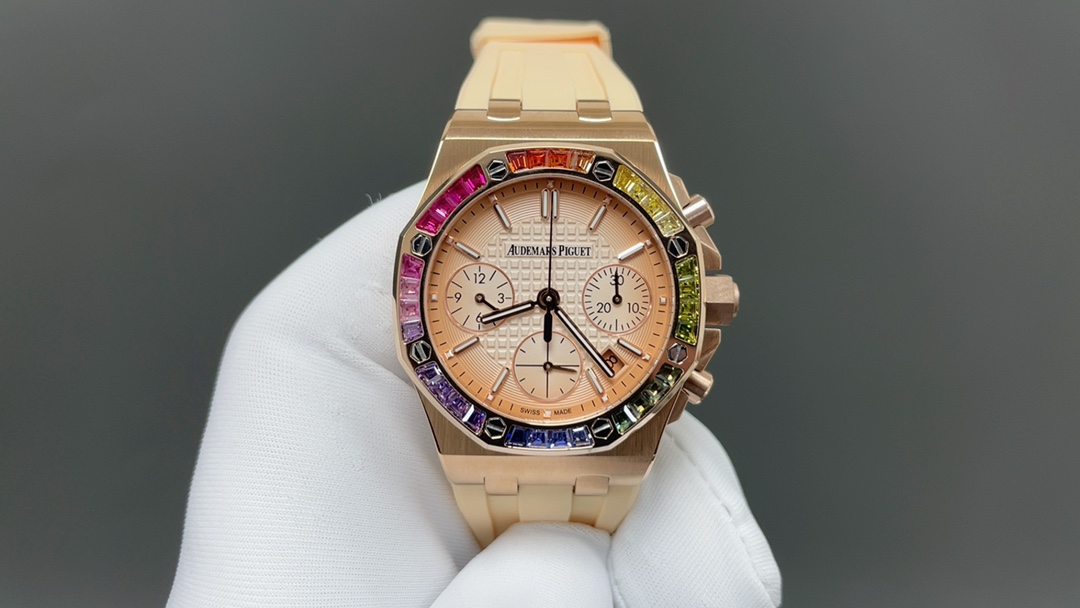 NO:715055,A different rainbow circle. The popular AP Audemars piguet 37mm Royal Oak Offshore Chronograph star has the same style rainbow circle limited ceiling. The sparkling precious gems and the classic octagonal case design collide with unique sparks. The rainbow is a symbol of optimism and romance. It exudes charming charm in every gesture and witnesses the romance of every moment in life. This 37mm diameter 'rainbow circle' uses a rose gold case and is paired with anti-glare sapphire crystal glass.  Set with 32 'rainbow-colored' rectangular-cut sapphires. Smoked rose gold dial engraved with 'Lady Tapisserie' plaid decoration. Matched with rose gold sub-dials. Rose gold luminescent hour markers and Royal Oak hands. The gemstones are arranged in gradient colors. Rose gold buttons and screw-in crown. Beige rubber strap with rose gold AP folding buckle. Equipped with movement. It has a 40-hour power reserve and a waterproof depth of 50 meters. It also has a chronograph function, hour minutes, small seconds and date display.  Back cover coding synchronization counter k15973, audemars19860909不一样的彩虹圈 热门款AP爱彼Audemars piguet 37mm皇家橡树离岸计时明星同款彩虹圈限量天花板 闪耀动人的珍贵宝石加上经典的八角表壳设计 碰撞与众不同的火花 彩虹是乐观与浪漫的象征 举手投足间散发迷人魅力 见证人生每刻浪漫  这枚37毫米直径大小的“彩虹圈”采用玫瑰金表壳 搭配防眩光处理蓝宝石水晶玻璃表镜 镶嵌32颗“彩虹色”长方形切割蓝宝石 烟熏玫瑰金色表盘镌刻 “Lady Tapisserie”格纹装饰 搭配玫瑰金色副表盘 玫瑰金荧光立体时标和皇家橡树指针 宝石按照渐变颜色排列 玫瑰金按钮和旋入式表冠 米色橡胶表带搭配玫瑰金AP字样折叠表扣 搭载机芯 具备40小时动力储存和50米的防水深度 同时具备计时功能 小时 分钟 小秒钟及日期显示等功能 后盖编码同步专柜k15973,,audemars,Watch