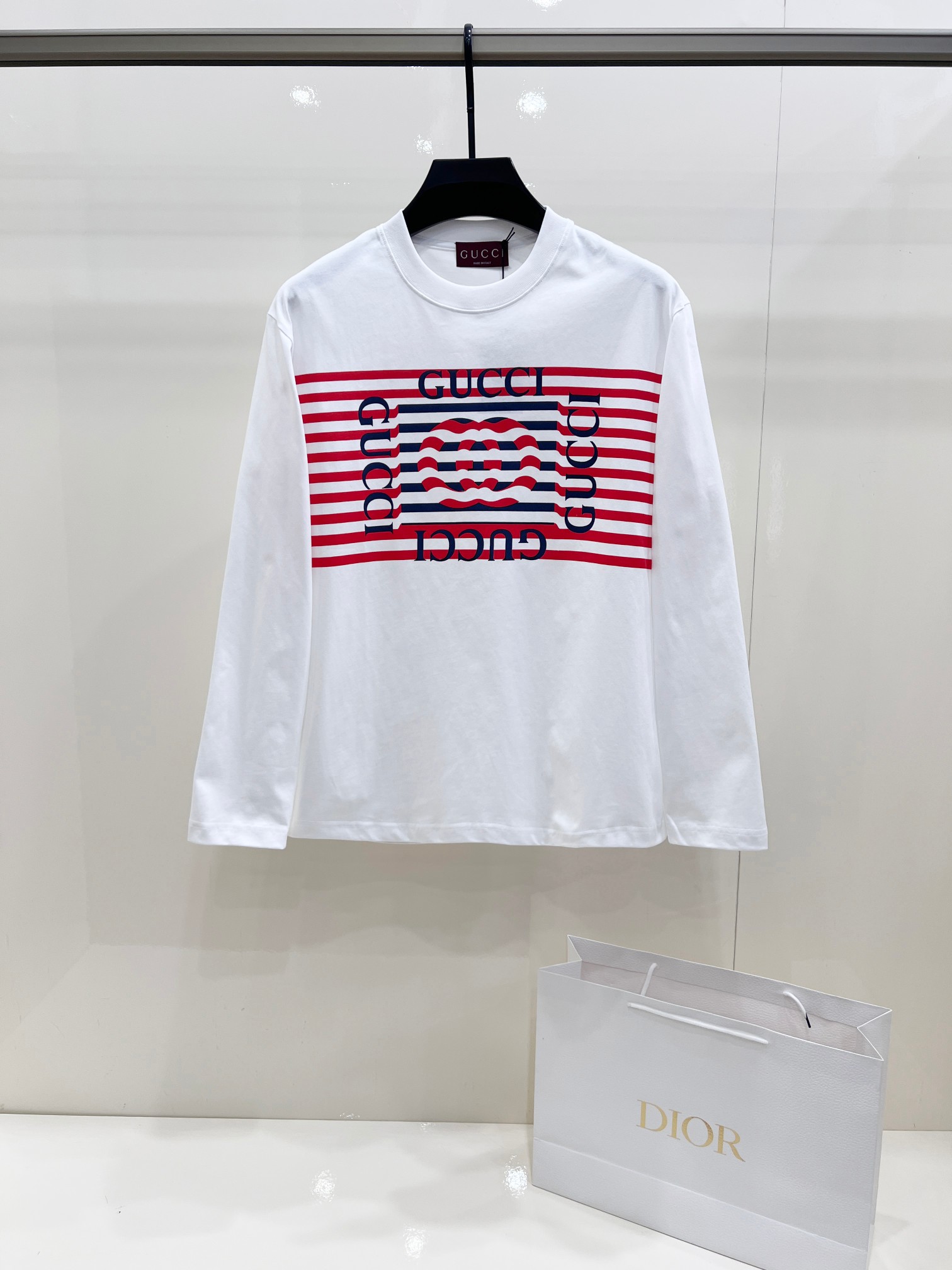 NO:550073,Gucci ocean style wave printed long-sleeved T-shirt, white base with red and blue stripes design, classic retro style. Made of high-quality pure cotton fabric, soft, comfortable and breathable. Unique striped letter print on the chest, fashionable and versatile. Made in Italy, exquisite workmanship, perfect details. Loose off-shoulder version, same style for men and women, suitable for daily wear. Three standards are complete. Sizes XS-XL  Length 70, size M, shoulder width 52, bust 108, length 72, size L, shoulder width 54, bust 112, length 74, size XL, shoulder width 56, bust 116, length 76, gucci, gucci, tees, t-shirt, alexander wang19860909Gucci古驰海洋风波浪印花长袖T恤,白色底红蓝条纹设计,经典复古风格.采用优质纯棉面料,柔软舒适透气.胸前独特条纹字母印花,时尚百搭.意大利制造,做工精致,细节完美.宽松落肩版型,男女同款,适合日常穿搭.三标齐全. 尺码 XS-XL XS码肩宽48 胸围100 衣长68 S码肩宽50 胸围104 衣长70 M码肩宽52 胸围108 衣长72 L码肩宽54 胸围112 衣长74 XL码肩宽56 胸围116 衣长76,,gucci,gucci,tees，t-shirt,alexander wang,Men's clothing
