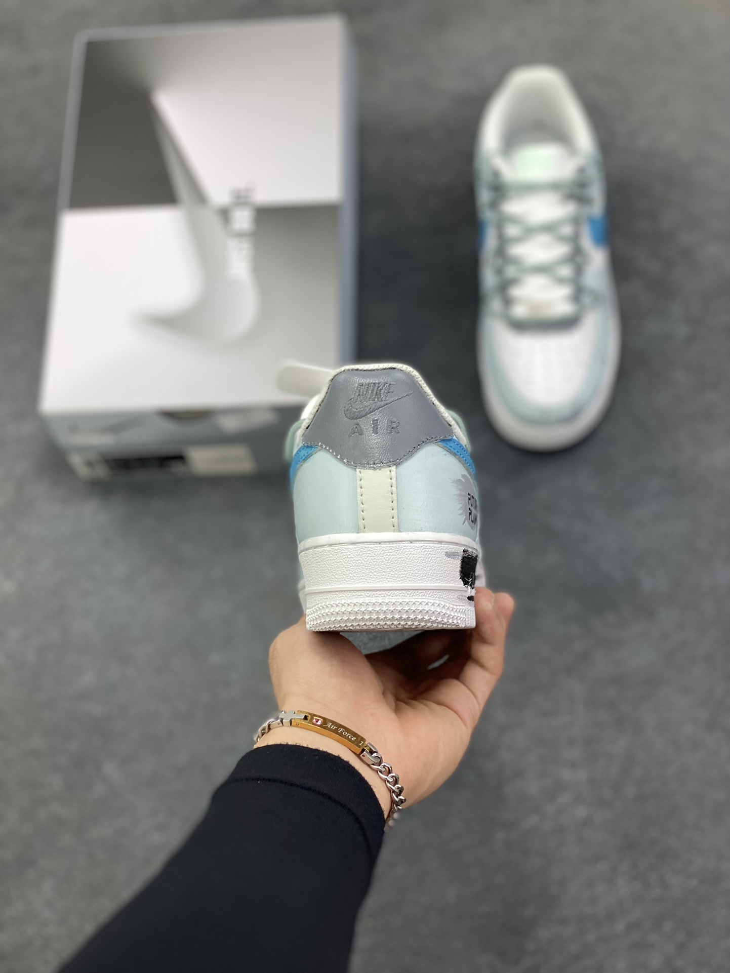 图片[4]-Nike Air Force 1\’07 Low \”Grey Tune Era\” 手绘涂鸦 灰调纪元 空军一号低帮休闲板鞋  #鞋身以层次丰富的灰白为基底，泼墨与做旧质感如时光留下的斑驳印记，又似未来城市废墟上的艺术涂鸦；蓝调 Swoosh 与 “FUTURE PLANS” 字样划破灰调沉寂，既是对先锋构想的直白宣告，也为整体注入灵动张力。它将复古鞋型的经典骨架，转化为承载未来畅想的载体 货号：LJ8822-202  尺码：36 36.5 37.5 38 38.5 39 40 40.5 41 42 42.5 43 44 44.5 45-选品中心