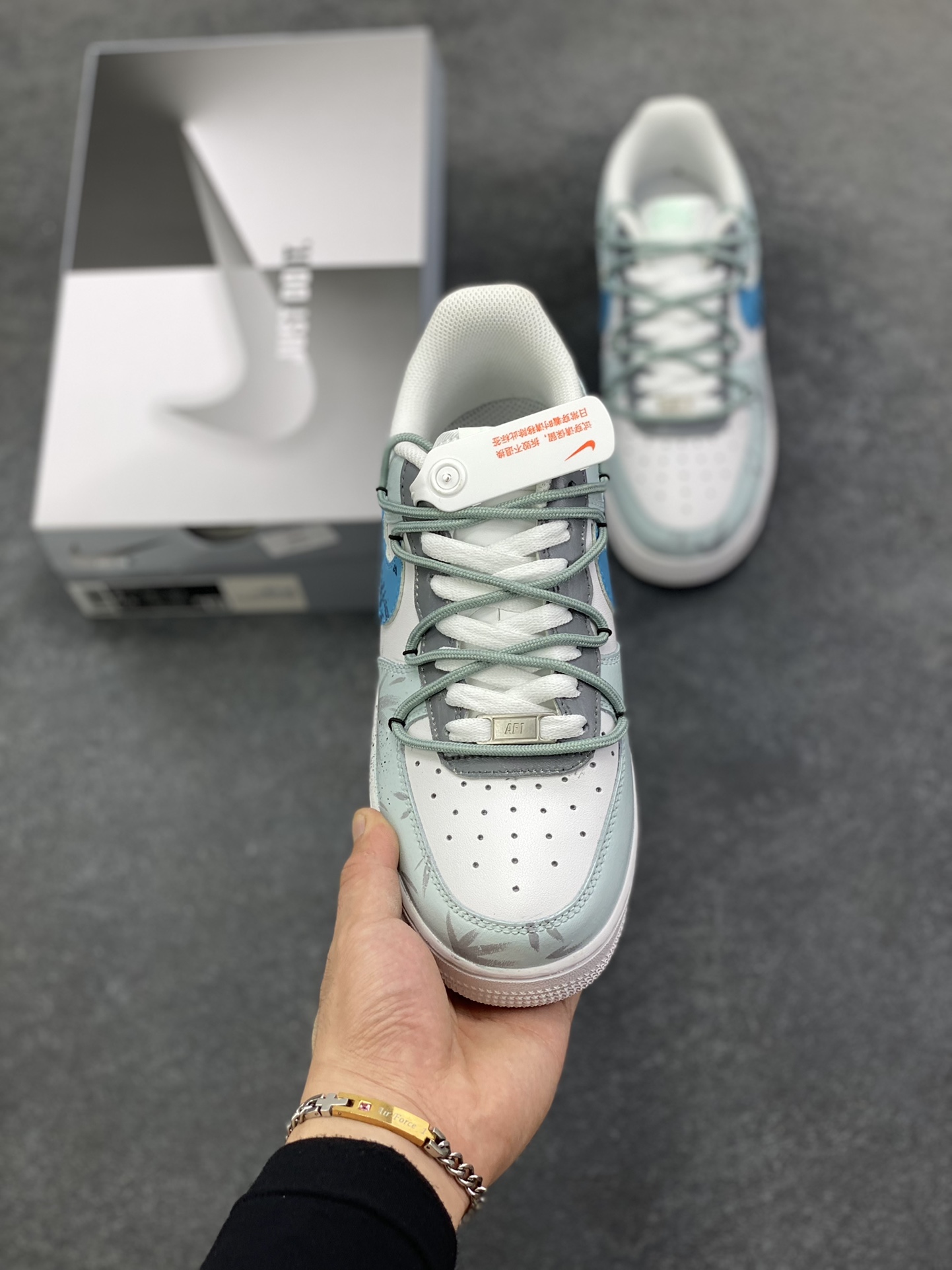 图片[2]-Nike Air Force 1\’07 Low \”Grey Tune Era\” 手绘涂鸦 灰调纪元 空军一号低帮休闲板鞋  #鞋身以层次丰富的灰白为基底，泼墨与做旧质感如时光留下的斑驳印记，又似未来城市废墟上的艺术涂鸦；蓝调 Swoosh 与 “FUTURE PLANS” 字样划破灰调沉寂，既是对先锋构想的直白宣告，也为整体注入灵动张力。它将复古鞋型的经典骨架，转化为承载未来畅想的载体 货号：LJ8822-202  尺码：36 36.5 37.5 38 38.5 39 40 40.5 41 42 42.5 43 44 44.5 45-选品中心