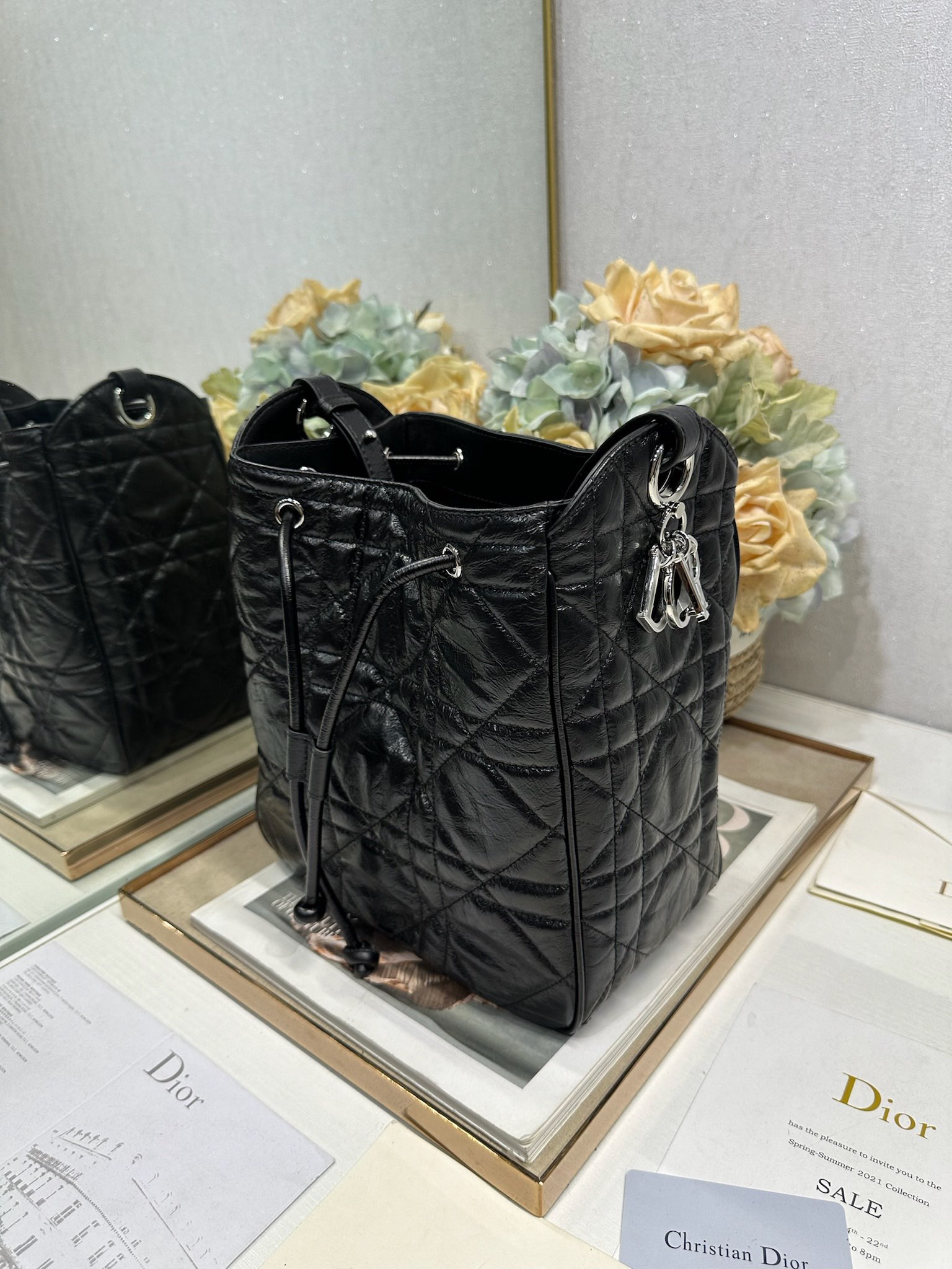 ✅中号 D-Motion 手袋「黑色褶皱」带可扫描高版本163变码芯片！
这款 D-Motion 手袋是二零二五冬季成衣系列新品，时尚实用的桶式设计，别具一格。采用黑色褶皱等材质精心制作，饰以藤格纹缉面线，柔软的版型搭配抽绳开合。带有宽敞的内部隔层、拉链口袋及两个侧面插袋，可收纳各种日常用品。中号款式，饰以银扣饰面金属 D.I.O.R. 吊饰更显精致，搭配滑动设计的可调节肩带，可肩背或斜挎。p700

D.I.O.R. 吊饰
抽绳开合
可调节皮革肩带
2 个内部插袋
内部拉链口袋

型号：2852
尺寸：23 x 24 x 13 厘米（长 x 高 x 宽）
可收纳 1 个 Voyageur 钱包、1 部手机、1 个卡夹、太阳眼镜和唇膏