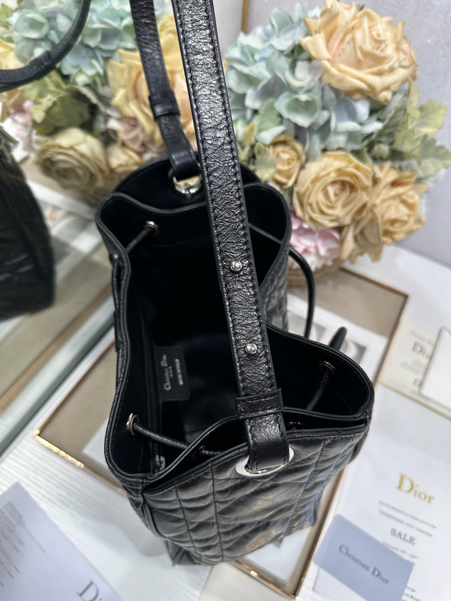 ✅中号 D-Motion 手袋「黑色褶皱」带可扫描高版本163变码芯片！
这款 D-Motion 手袋是二零二五冬季成衣系列新品，时尚实用的桶式设计，别具一格。采用黑色褶皱等材质精心制作，饰以藤格纹缉面线，柔软的版型搭配抽绳开合。带有宽敞的内部隔层、拉链口袋及两个侧面插袋，可收纳各种日常用品。中号款式，饰以银扣饰面金属 D.I.O.R. 吊饰更显精致，搭配滑动设计的可调节肩带，可肩背或斜挎。p700

D.I.O.R. 吊饰
抽绳开合
可调节皮革肩带
2 个内部插袋
内部拉链口袋

型号：2852
尺寸：23 x 24 x 13 厘米（长 x 高 x 宽）
可收纳 1 个 Voyageur 钱包、1 部手机、1 个卡夹、太阳眼镜和唇膏