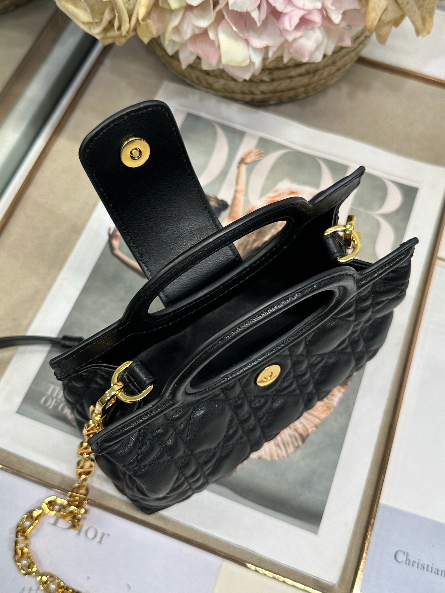 Dior Jolie Top Handle 迷你链条手袋「黑色」
这款 Dior Jolie Top Handle 迷你链条手袋是二零二六早春成衣系列新品，呈现出优雅精致的设计。采用黑色羊皮革精心制作，饰以藤格纹，翻盖点缀以金色饰面金属 CD 标志和白色树脂珠饰。内设一个隔层，可收纳各种日常用品。搭配双顶部手柄和可调节、可拆卸 CD 链条肩带，肩带由皮革带和 CD 链环组成，饰以白色树脂珠饰，可舒适手提、肩背或斜挎，可与日常或晚装造型搭配。
磁性翻盖开合正面饰以 CD 扣环和白色树脂珠饰
1 个隔层
双顶部皮革手柄
可调节、可拆卸的链条饰以树脂珠饰和皮革带

型号：3123
尺寸：18.5 x 13 x 8.5 厘米（长 x 高 x 宽）
可收纳 1 部手机、1 个卡夹、太阳眼镜和唇膏