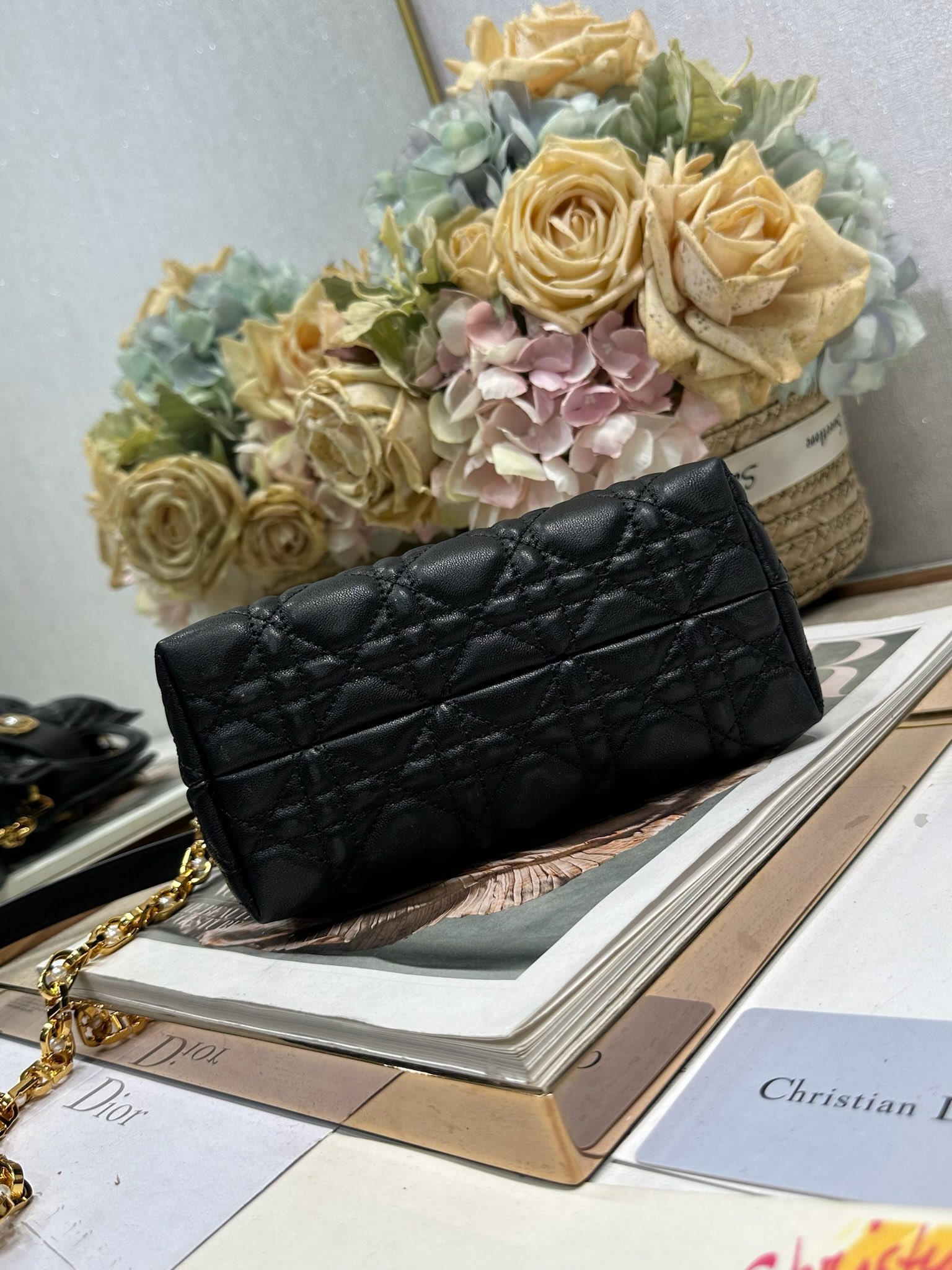 Dior Jolie Top Handle 迷你链条手袋「黑色」
这款 Dior Jolie Top Handle 迷你链条手袋是二零二六早春成衣系列新品，呈现出优雅精致的设计。采用黑色羊皮革精心制作，饰以藤格纹，翻盖点缀以金色饰面金属 CD 标志和白色树脂珠饰。内设一个隔层，可收纳各种日常用品。搭配双顶部手柄和可调节、可拆卸 CD 链条肩带，肩带由皮革带和 CD 链环组成，饰以白色树脂珠饰，可舒适手提、肩背或斜挎，可与日常或晚装造型搭配。
磁性翻盖开合正面饰以 CD 扣环和白色树脂珠饰
1 个隔层
双顶部皮革手柄
可调节、可拆卸的链条饰以树脂珠饰和皮革带

型号：3123
尺寸：18.5 x 13 x 8.5 厘米（长 x 高 x 宽）
可收纳 1 部手机、1 个卡夹、太阳眼镜和唇膏