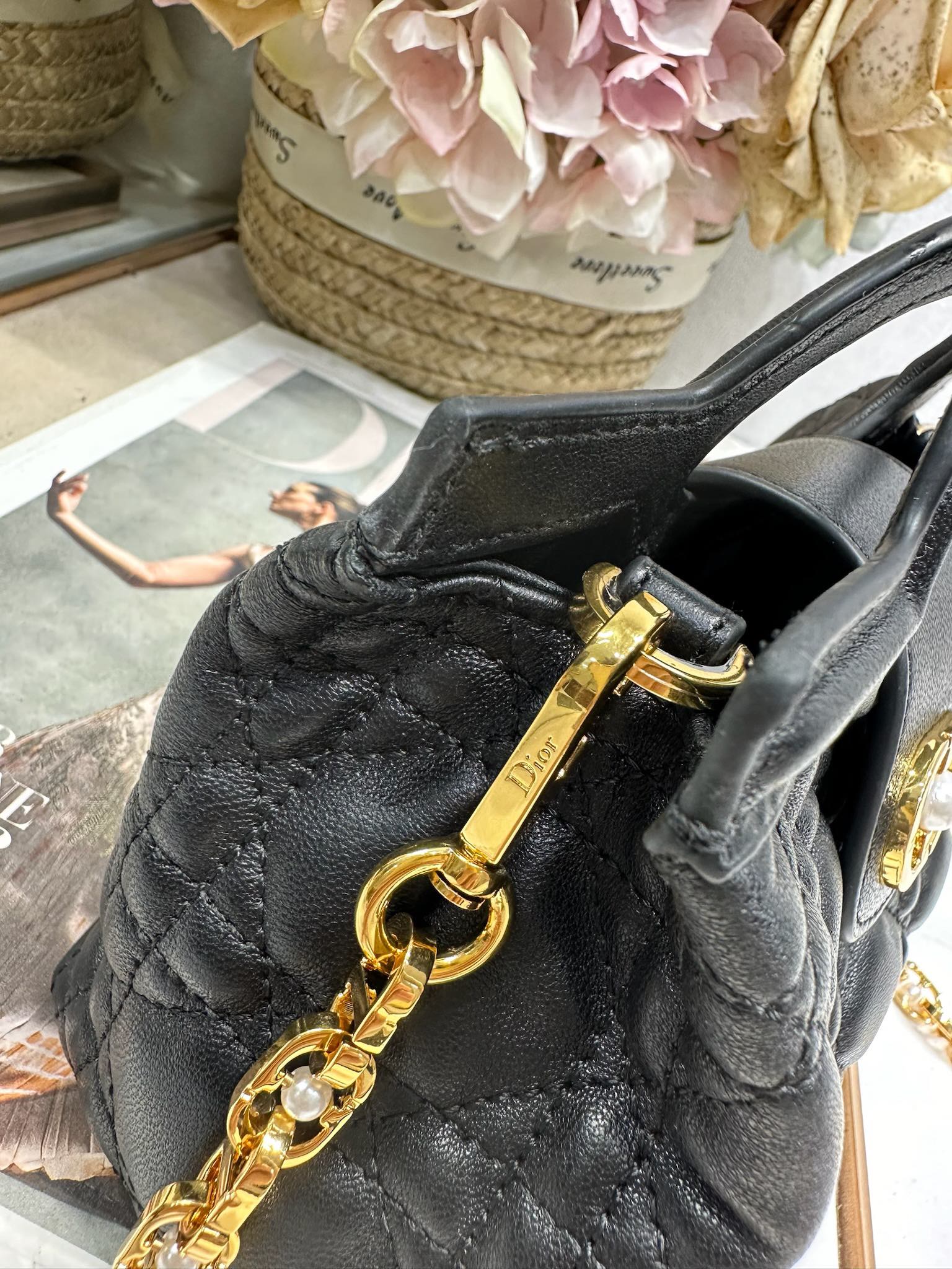 Dior Jolie Top Handle 迷你链条手袋「黑色」
这款 Dior Jolie Top Handle 迷你链条手袋是二零二六早春成衣系列新品，呈现出优雅精致的设计。采用黑色羊皮革精心制作，饰以藤格纹，翻盖点缀以金色饰面金属 CD 标志和白色树脂珠饰。内设一个隔层，可收纳各种日常用品。搭配双顶部手柄和可调节、可拆卸 CD 链条肩带，肩带由皮革带和 CD 链环组成，饰以白色树脂珠饰，可舒适手提、肩背或斜挎，可与日常或晚装造型搭配。
磁性翻盖开合正面饰以 CD 扣环和白色树脂珠饰
1 个隔层
双顶部皮革手柄
可调节、可拆卸的链条饰以树脂珠饰和皮革带

型号：3123
尺寸：18.5 x 13 x 8.5 厘米（长 x 高 x 宽）
可收纳 1 部手机、1 个卡夹、太阳眼镜和唇膏