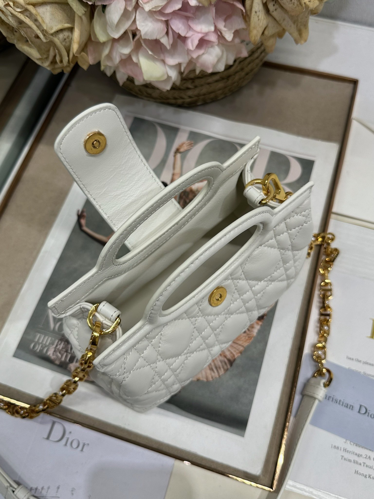 Dior Jolie Top Handle 迷你链条手袋「白色」
这款 Dior Jolie Top Handle 迷你链条手袋是二零二六早春成衣系列新品，呈现出优雅精致的设计。采用奶白色羊皮革精心制作，饰以藤格纹，翻盖点缀以金色饰面金属 CD 标志和白色树脂珠饰。内设一个隔层，可收纳各种日常用品。搭配双顶部手柄和可调节、可拆卸 CD 链条肩带，肩带由皮革带和 CD 链环组成，饰以白色树脂珠饰，可舒适手提、肩背或斜挎，可与日常或晚装造型搭配。p570
磁性翻盖开合正面饰以 CD 扣环和白色树脂珠饰
1 个隔层
双顶部皮革手柄
可调节、可拆卸的链条饰以树脂珠饰和皮革带

型号：3123
尺寸：18.5 x 13 x 8.5 厘米（长 x 高 x 宽）
可收纳 1 部手机、1 个卡夹、太阳眼镜和唇膏
