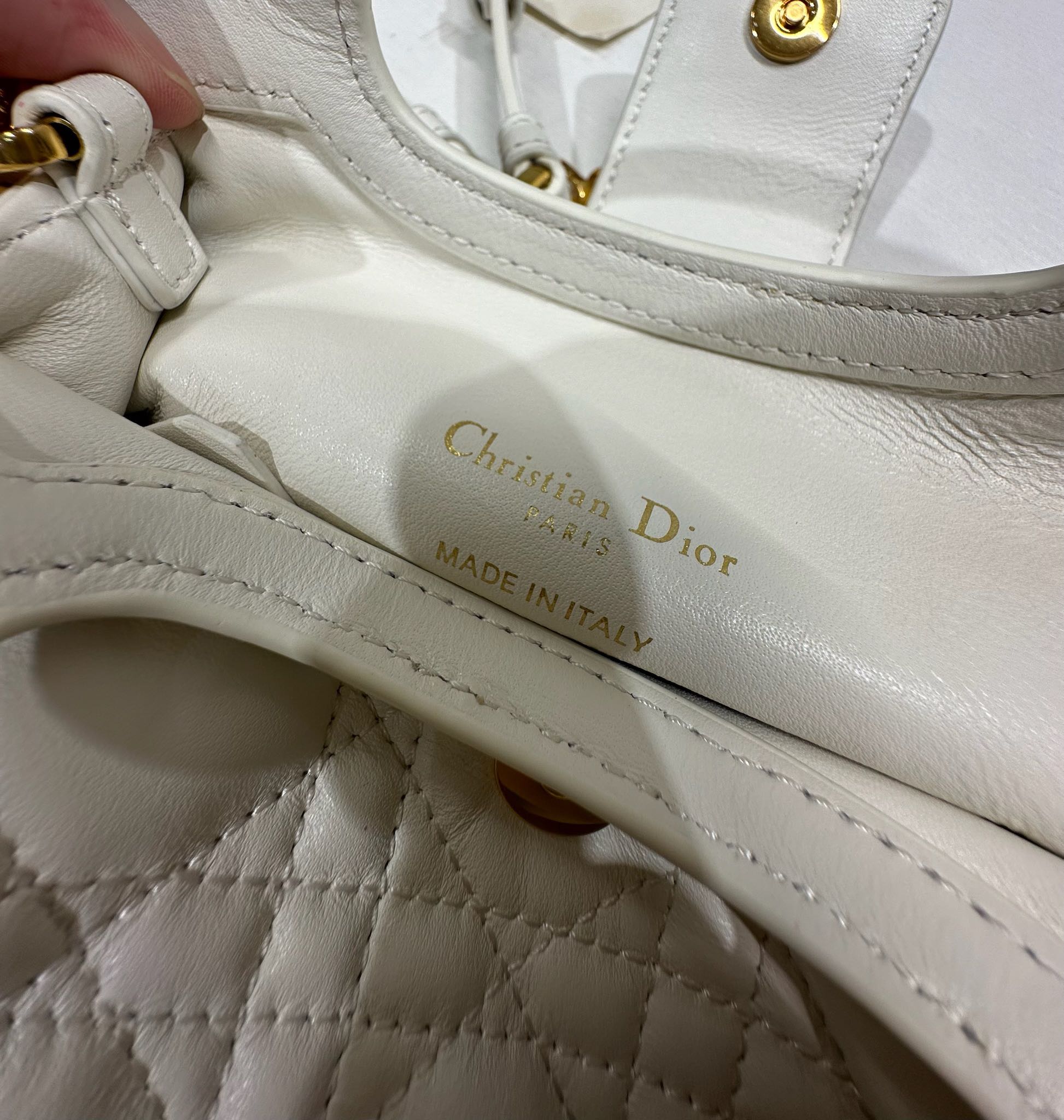 Dior Jolie Top Handle 迷你链条手袋「白色」
这款 Dior Jolie Top Handle 迷你链条手袋是二零二六早春成衣系列新品，呈现出优雅精致的设计。采用奶白色羊皮革精心制作，饰以藤格纹，翻盖点缀以金色饰面金属 CD 标志和白色树脂珠饰。内设一个隔层，可收纳各种日常用品。搭配双顶部手柄和可调节、可拆卸 CD 链条肩带，肩带由皮革带和 CD 链环组成，饰以白色树脂珠饰，可舒适手提、肩背或斜挎，可与日常或晚装造型搭配。p570
磁性翻盖开合正面饰以 CD 扣环和白色树脂珠饰
1 个隔层
双顶部皮革手柄
可调节、可拆卸的链条饰以树脂珠饰和皮革带

型号：3123
尺寸：18.5 x 13 x 8.5 厘米（长 x 高 x 宽）
可收纳 1 部手机、1 个卡夹、太阳眼镜和唇膏