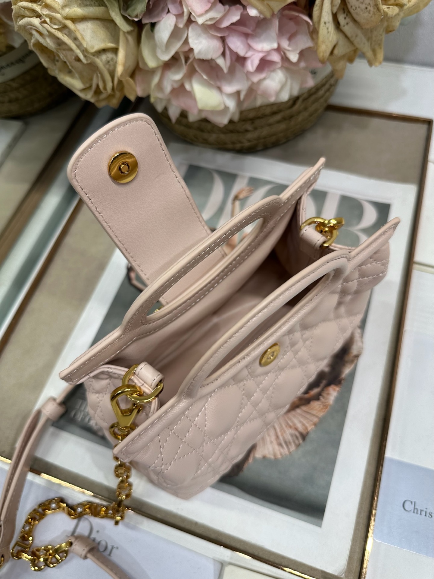 Dior Jolie Top Handle 迷你链条手袋「粉色」
这款 Dior Jolie Top Handle 迷你链条手袋是二零二六早春成衣系列新品，呈现出优雅精致的设计。采用粉色羊皮革精心制作，饰以藤格纹，翻盖点缀以金色饰面金属 CD 标志和白色树脂珠饰。内设一个隔层，可收纳各种日常用品。搭配双顶部手柄和可调节、可拆卸 CD 链条肩带，肩带由皮革带和 CD 链环组成，饰以白色树脂珠饰，可舒适手提、肩背或斜挎，可与日常或晚装造型搭配。p570
磁性翻盖开合正面饰以 CD 扣环和白色树脂珠饰
1 个隔层
双顶部皮革手柄
可调节、可拆卸的链条饰以树脂珠饰和皮革带

型号：3123
尺寸：18.5 x 13 x 8.5 厘米（长 x 高 x 宽）
可收纳 1 部手机、1 个卡夹、太阳眼镜和唇膏