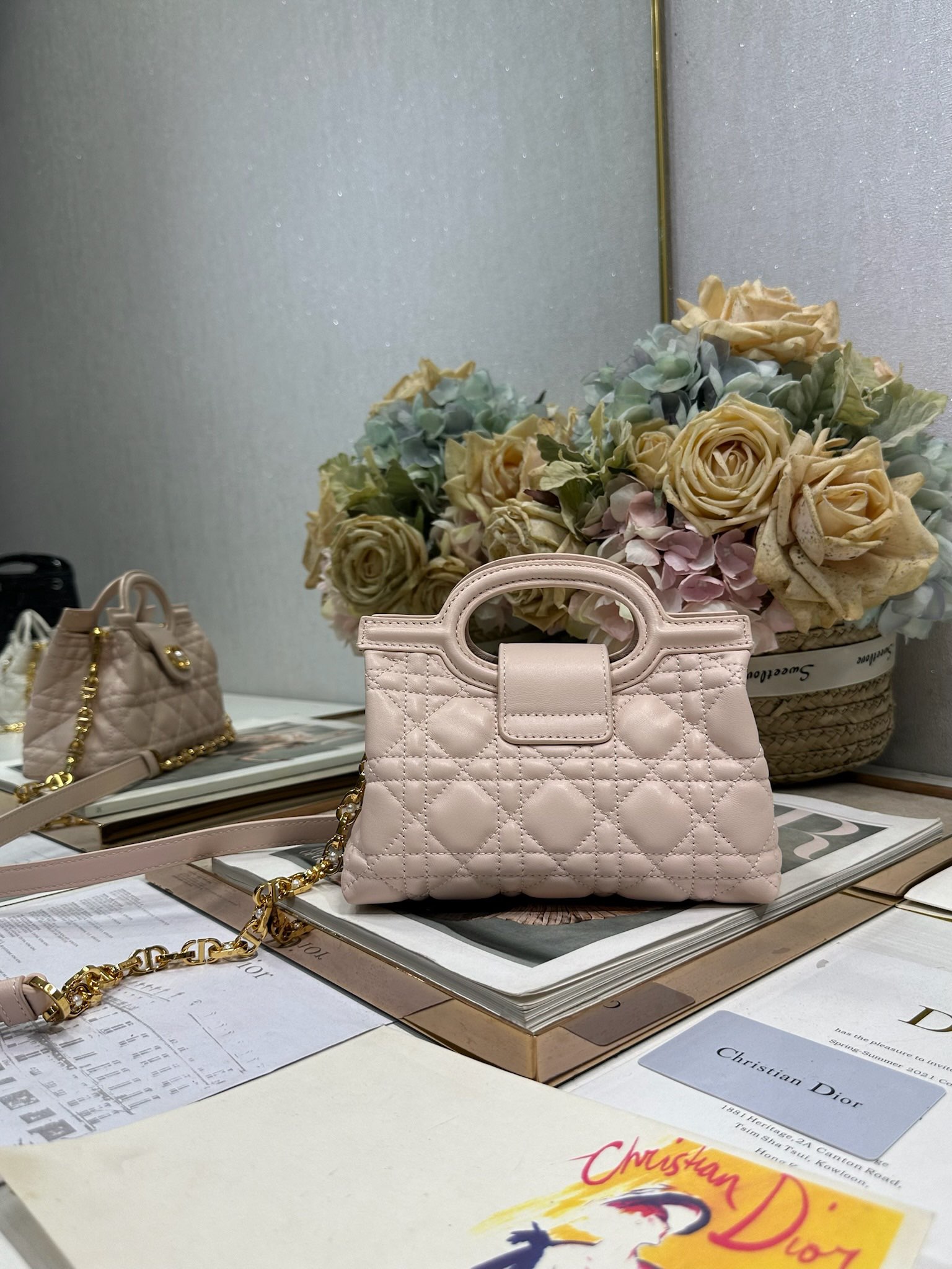 Dior Jolie Top Handle 迷你链条手袋「粉色」
这款 Dior Jolie Top Handle 迷你链条手袋是二零二六早春成衣系列新品，呈现出优雅精致的设计。采用粉色羊皮革精心制作，饰以藤格纹，翻盖点缀以金色饰面金属 CD 标志和白色树脂珠饰。内设一个隔层，可收纳各种日常用品。搭配双顶部手柄和可调节、可拆卸 CD 链条肩带，肩带由皮革带和 CD 链环组成，饰以白色树脂珠饰，可舒适手提、肩背或斜挎，可与日常或晚装造型搭配。p570
磁性翻盖开合正面饰以 CD 扣环和白色树脂珠饰
1 个隔层
双顶部皮革手柄
可调节、可拆卸的链条饰以树脂珠饰和皮革带

型号：3123
尺寸：18.5 x 13 x 8.5 厘米（长 x 高 x 宽）
可收纳 1 部手机、1 个卡夹、太阳眼镜和唇膏