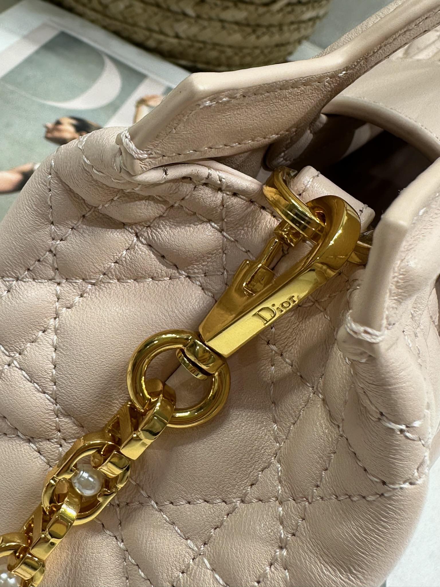 Dior Jolie Top Handle 迷你链条手袋「粉色」
这款 Dior Jolie Top Handle 迷你链条手袋是二零二六早春成衣系列新品，呈现出优雅精致的设计。采用粉色羊皮革精心制作，饰以藤格纹，翻盖点缀以金色饰面金属 CD 标志和白色树脂珠饰。内设一个隔层，可收纳各种日常用品。搭配双顶部手柄和可调节、可拆卸 CD 链条肩带，肩带由皮革带和 CD 链环组成，饰以白色树脂珠饰，可舒适手提、肩背或斜挎，可与日常或晚装造型搭配。p570
磁性翻盖开合正面饰以 CD 扣环和白色树脂珠饰
1 个隔层
双顶部皮革手柄
可调节、可拆卸的链条饰以树脂珠饰和皮革带

型号：3123
尺寸：18.5 x 13 x 8.5 厘米（长 x 高 x 宽）
可收纳 1 部手机、1 个卡夹、太阳眼镜和唇膏