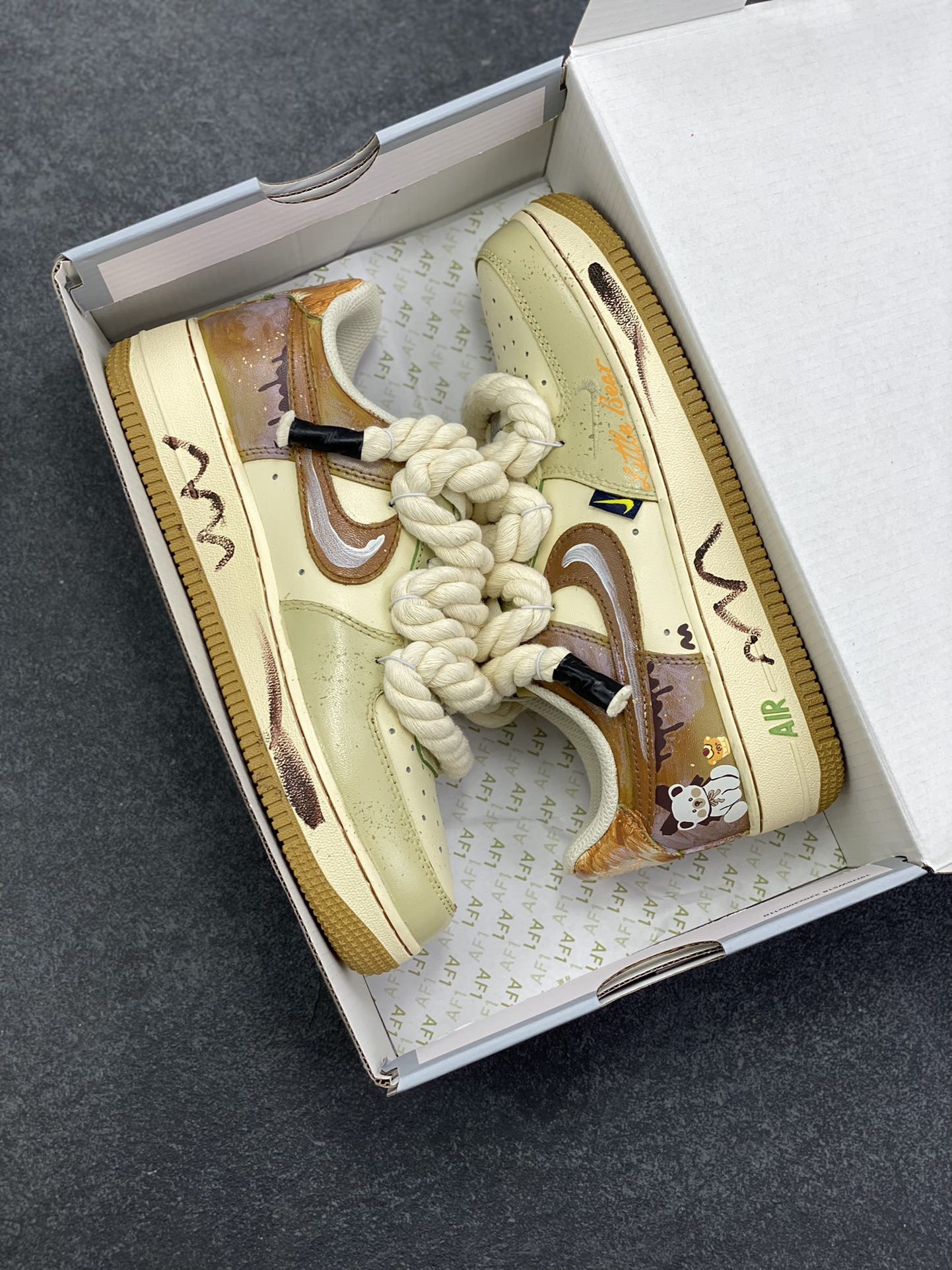 图片[9]-手绘涂鸦“奶咖小熊”Nike Air Force 1 “Milk coffee bear”空军一号定制板鞋 当奶咖的温柔色调邂逅小熊的萌趣灵魂，这双“奶咖小熊”定制球鞋便成了潮流与治愈的完美融合。奶棕与米白的配色如丝滑奶咖般温润，复古做旧质感为鞋身蒙上一层时光滤镜。绳索鞋带的粗犷与小熊、甜品涂鸦的软萌形成反差萌，鞋侧“Little bear”字样与可爱熊仔图案呼应，将童趣基因刻入设计 货号：XL2321-666 尺码：36 36.5 37.5 38 38.5 39 40 40.5 41 42 42.5 43 44 44.5 45-选品中心