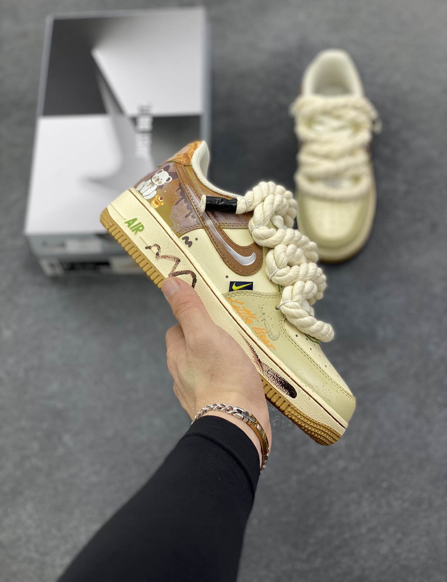 手绘涂鸦“奶咖小熊”Nike Air Force 1 “Milk coffee bear”空军一号定制板鞋 当奶咖的温柔色调邂逅小熊的萌趣灵魂，这双“奶咖小熊”定制球鞋便成了潮流与治愈的完美融合。奶棕与米白的配色如丝滑奶咖般温润，复古做旧质感为鞋身蒙上一层时光滤镜。绳索鞋带的粗犷与小熊、甜品涂鸦的软萌形成反差萌，鞋侧“Little bear”字样与可爱熊仔图案呼应，将童趣基因刻入设计 货号：XL2321-666 尺码：36 36.5 37.5 38 38.5 39 40 40.5 41 42 42.5 43 44 44.5 45-选品中心