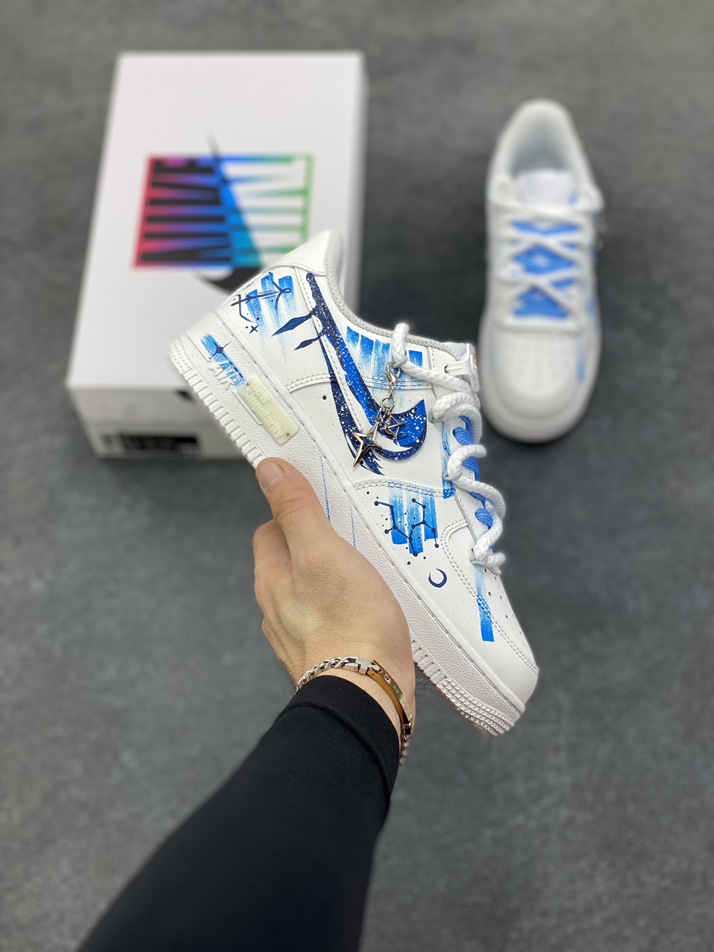 手绘涂鸦“射手座”十二星座系列 Nike Air Force 1 “Sagittarius”空军一号定制板鞋 以纯净白为底，泼洒蓝调星芒，手绘的笔触如射手座的箭一般肆意张扬，将星座符号、星空轨迹化作涂鸦艺术，在鞋身肆意铺陈。标志性Swoosh上的蓝黑渐变，似宇宙漩涡裹挟着射手的冒险精神；鞋侧的星座图案与星月元素，为整体注入梦幻感，每一处细节都在诉说着射手对未知的渴求与对自由的偏执 货号：星座11231221 尺码：36 36.5 37.5 38 38.5 39 40 40.5 41 42 42.5 43 44 44.5 45-选品中心