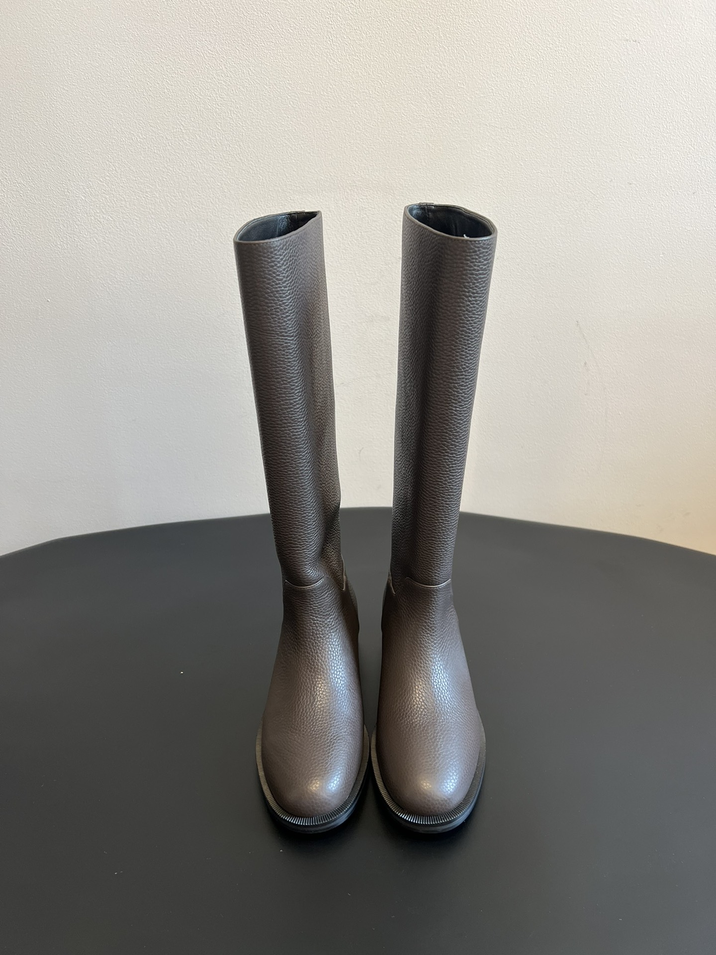 Khaite 25ss 荔枝纹皮革长靴采用荔枝纹皮革材质，触感细腻且质感高级，呈现出深灰色和棕灰色两种低