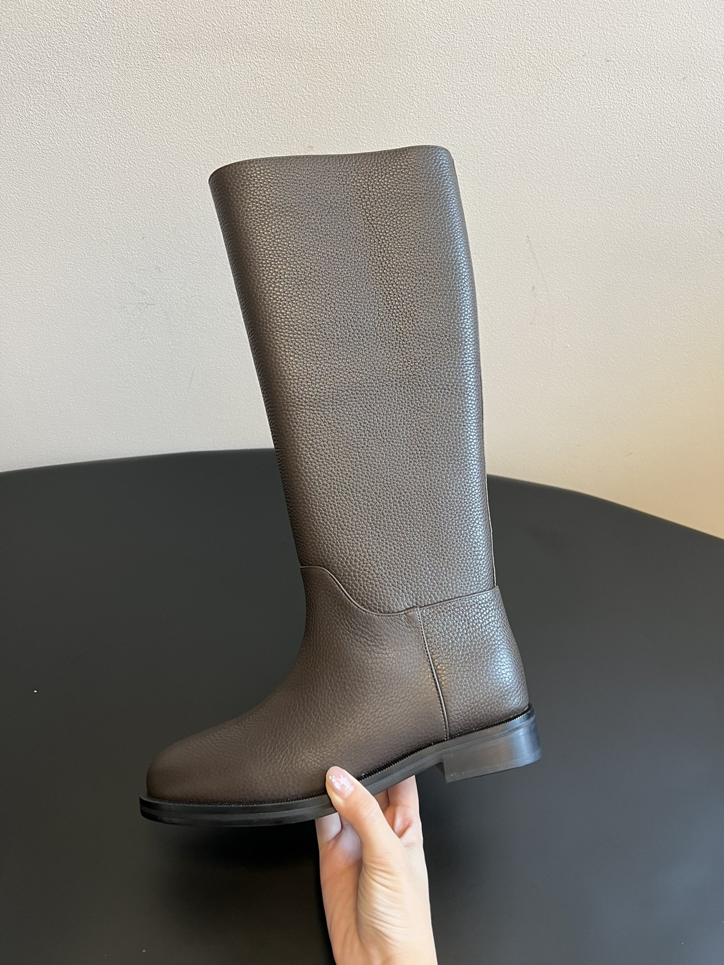 Khaite 25ss 荔枝纹皮革长靴采用荔枝纹皮革材质，触感细腻且质感高级，呈现出深灰色和棕灰色两种低