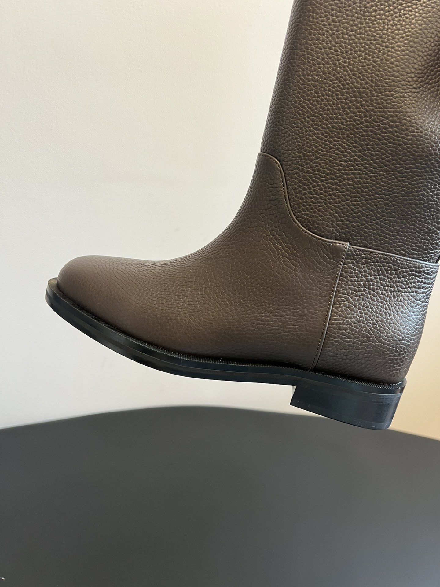 Khaite 25ss 荔枝纹皮革长靴采用荔枝纹皮革材质，触感细腻且质感高级，呈现出深灰色和棕灰色两种低