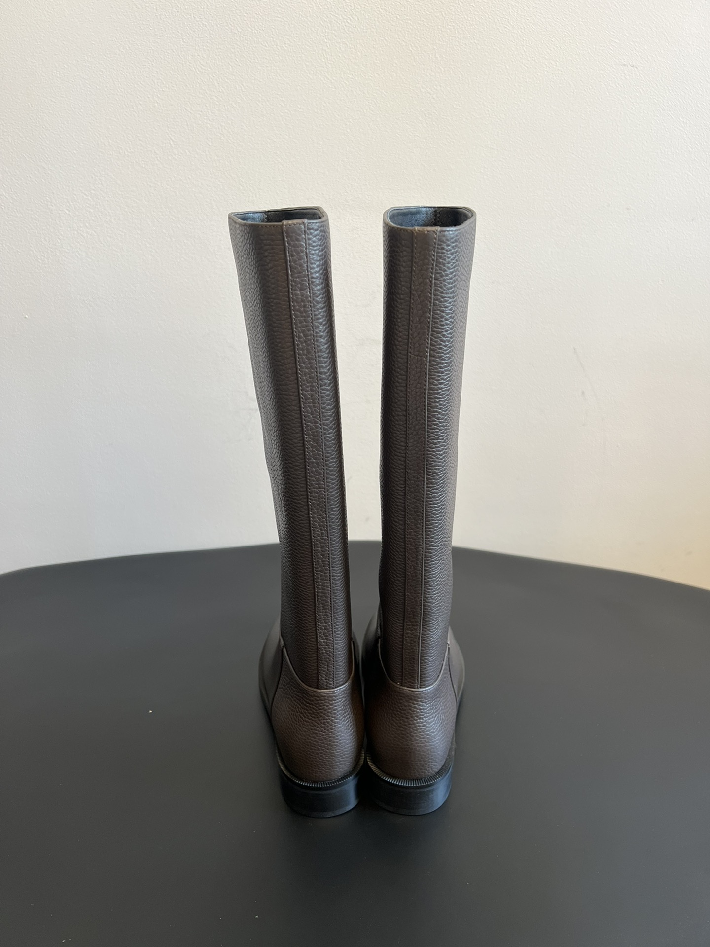 Khaite 25ss 荔枝纹皮革长靴采用荔枝纹皮革材质，触感细腻且质感高级，呈现出深灰色和棕灰色两种低