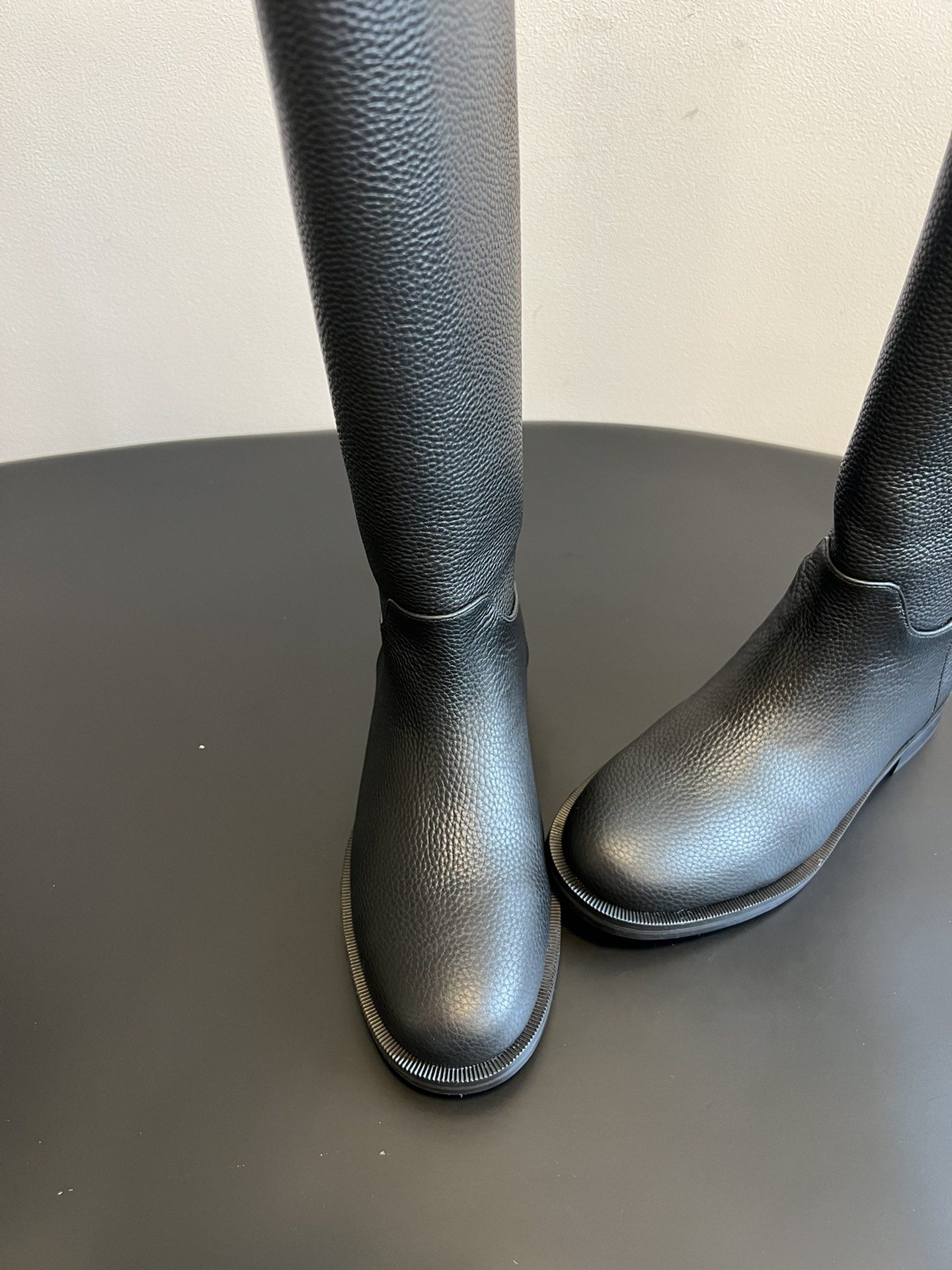 Khaite 25ss 荔枝纹皮革长靴采用荔枝纹皮革材质，触感细腻且质感高级，呈现出深灰色和棕灰色两种低