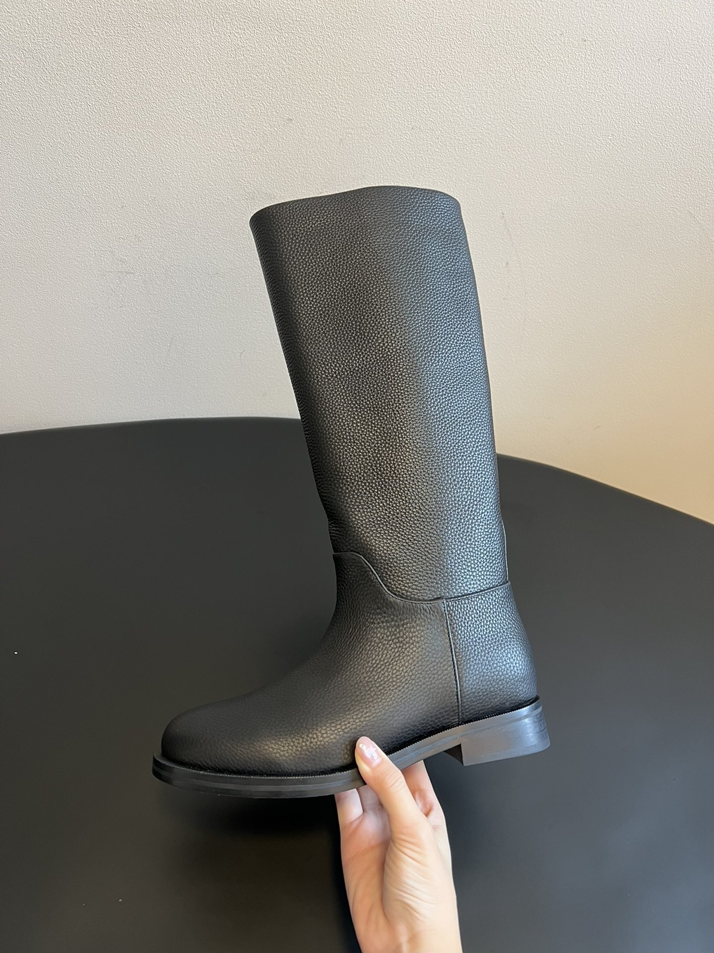 Khaite 25ss 荔枝纹皮革长靴采用荔枝纹皮革材质，触感细腻且质感高级，呈现出深灰色和棕灰色两种低