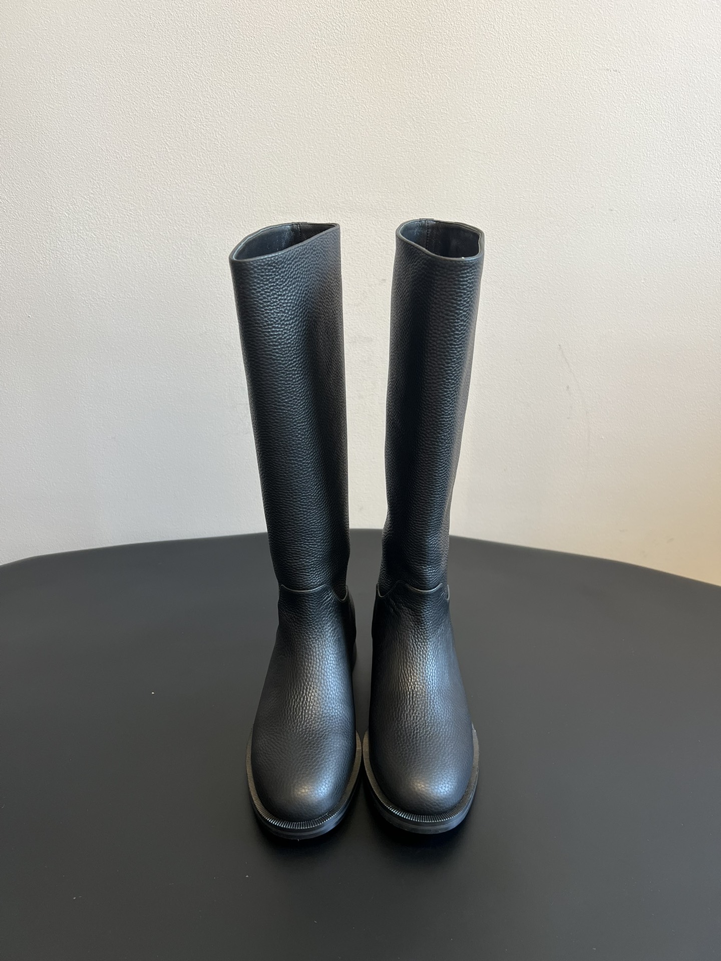 Khaite 25ss 荔枝纹皮革长靴采用荔枝纹皮革材质，触感细腻且质感高级，呈现出深灰色和棕灰色两种低