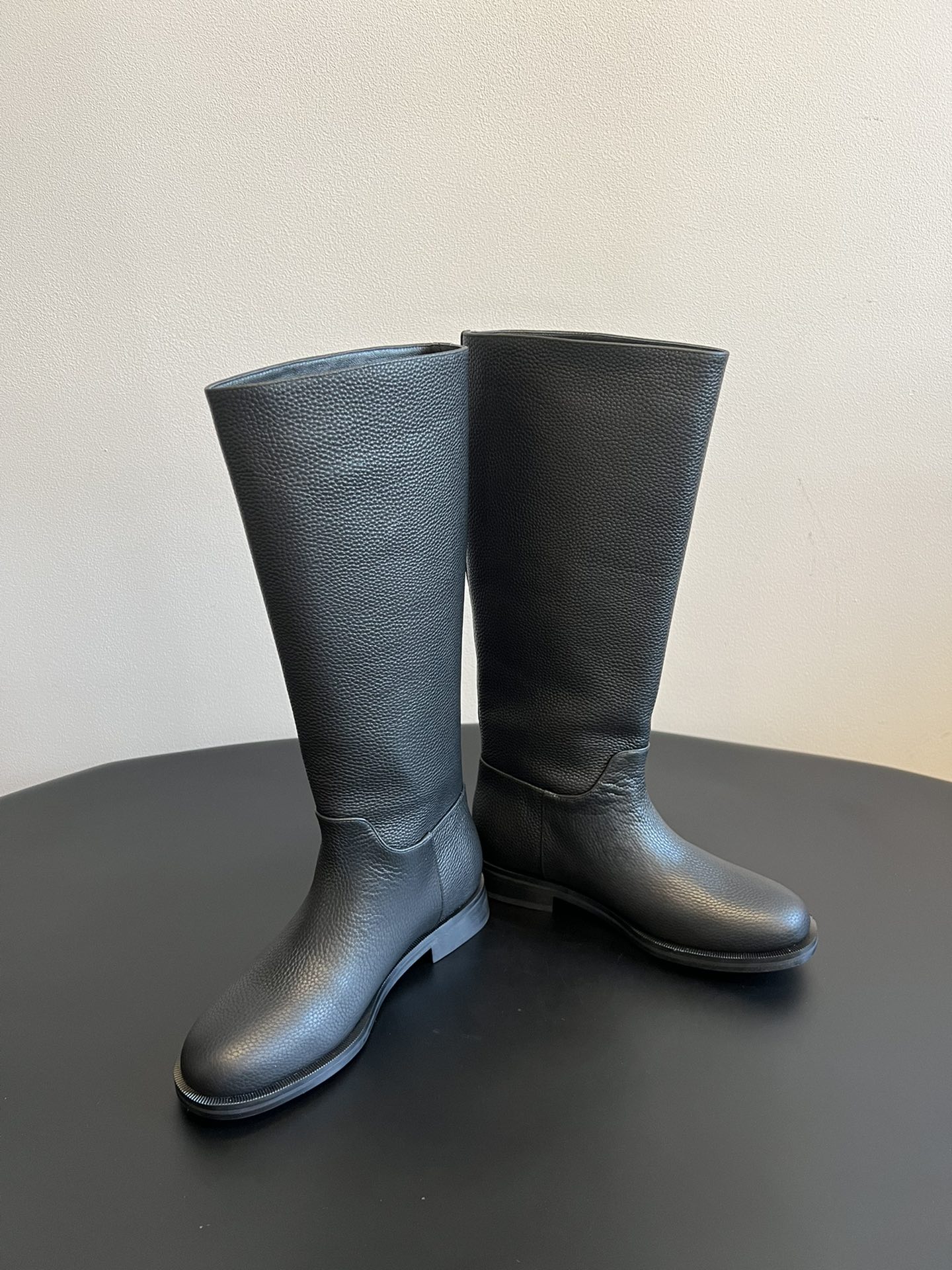 Khaite 25ss 荔枝纹皮革长靴采用荔枝纹皮革材质，触感细腻且质感高级，呈现出深灰色和棕灰色两种低