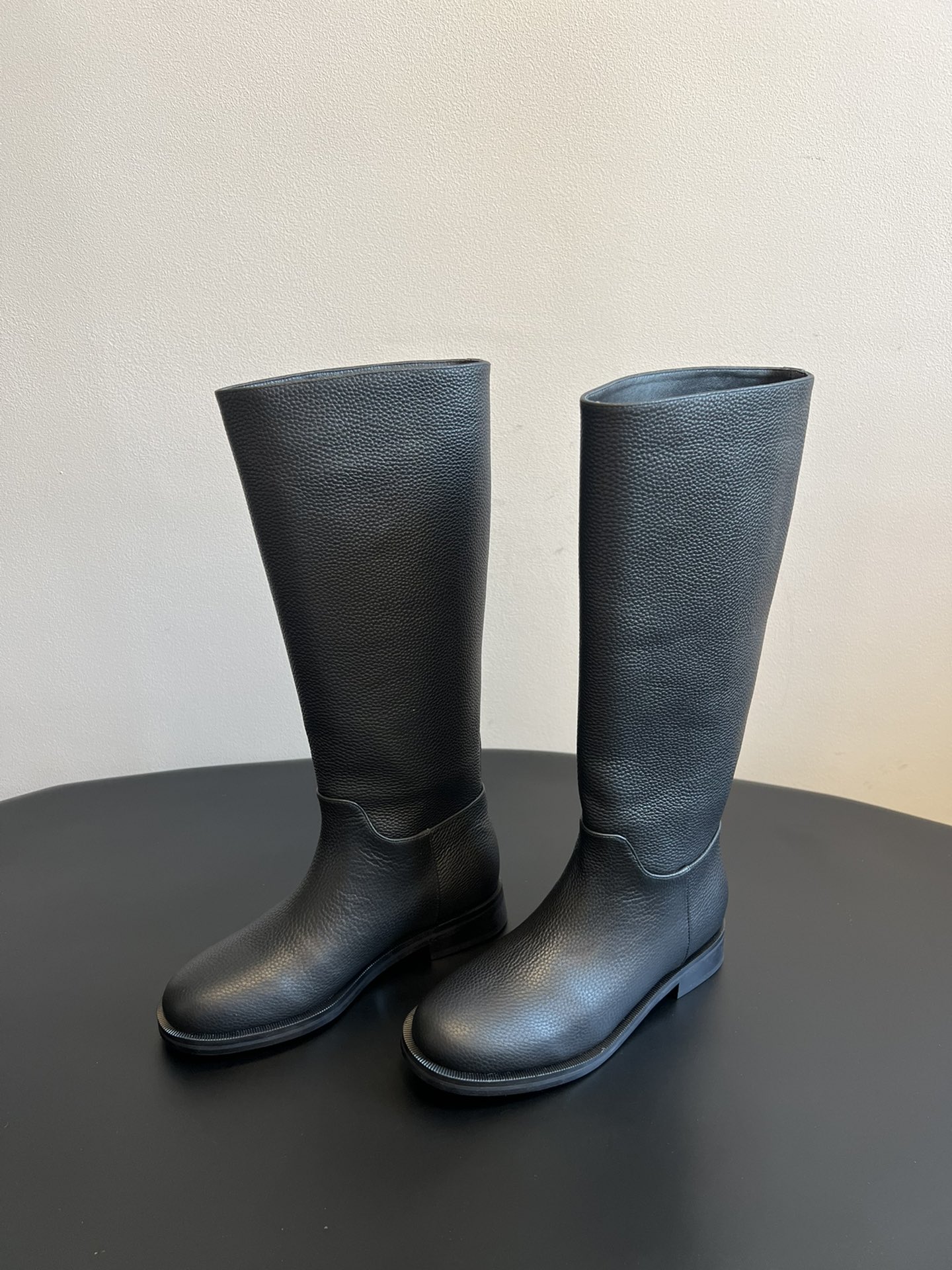 Khaite 25ss 荔枝纹皮革长靴采用荔枝纹皮革材质，触感细腻且质感高级，呈现出深灰色和棕灰色两种低