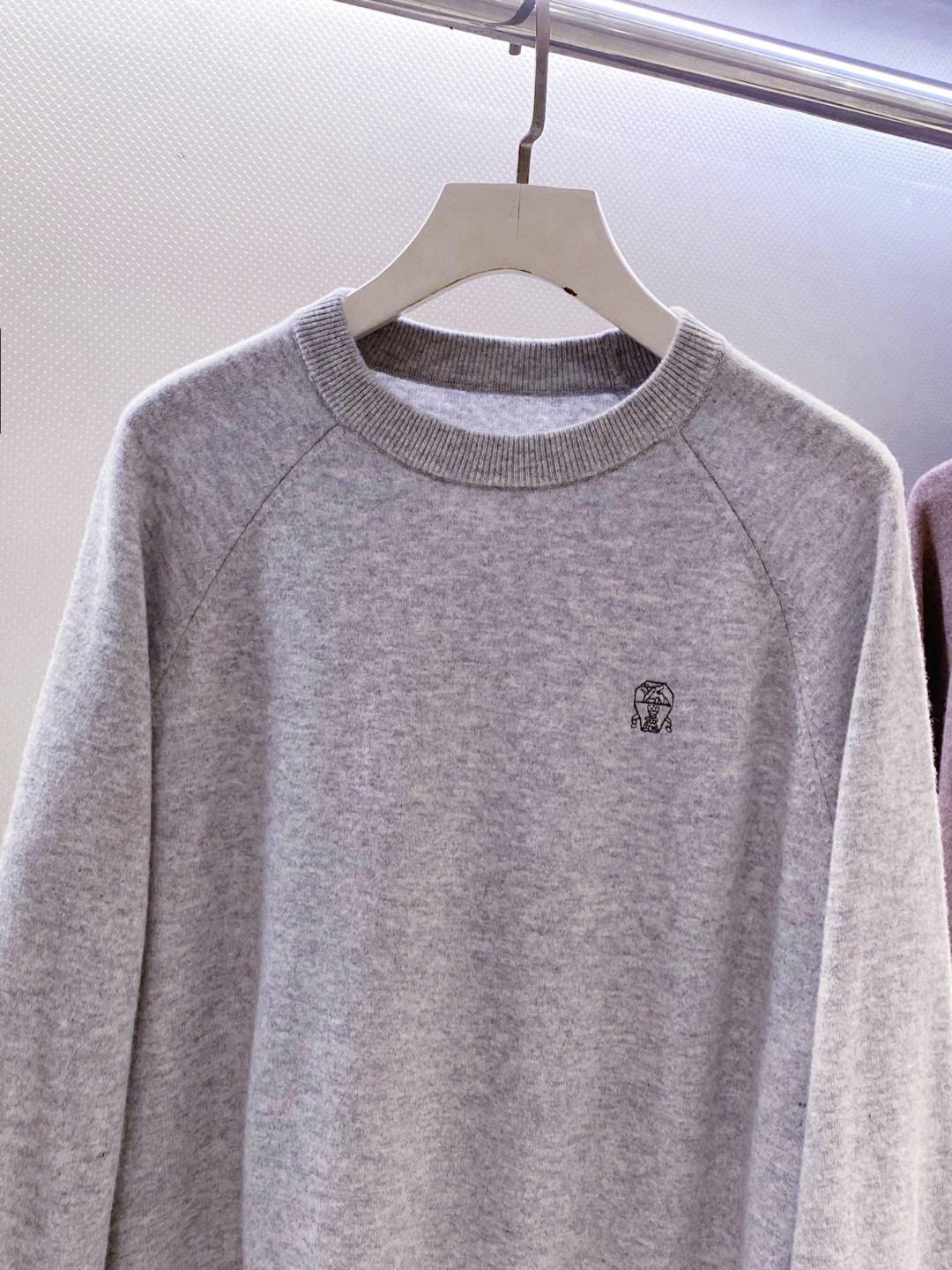 BC~经典logo刺绣叉肩圆领毛衣
秋冬新品
精选高支美丽诺羊毛，把柔软与经典，织进日常质感里&hellip;.触感是肉眼可见的细腻软糯&mdash;&mdash;没有普通羊毛的扎肤感，贴身穿亲肤不刺痒，自带天然的温煦包裹感，既保留羊毛的保暖性，又兼具轻盈透气的特质，秋冬单穿不厚重，叠穿不臃肿。
圆领+叉肩连袖的版型藏着不挑人的包容感！圆领恰到好处不挑脸型更不挑内搭；叉肩袖设计弱化肩线棱角，合身不紧绷的版型，无论是搭任何裤子都能轻松适配。
胸前经典logo刺绣是点睛之笔：没有繁复花样，仅以精致针脚将品牌标识绣于衣身，线条清晰不突兀，既有品牌辨识度又不张扬。整体简约却不简单，把BC一贯的低调优雅藏在羊毛的柔软肌理与经典设计里，日常穿、通勤穿都能透出不经意的质感。

颜色：黑色、驼色、浅灰色
规格：M--XXL
    P310
M码：连肩袖74、胸围110、衣长67
L码：连肩袖75、胸围114、衣长68